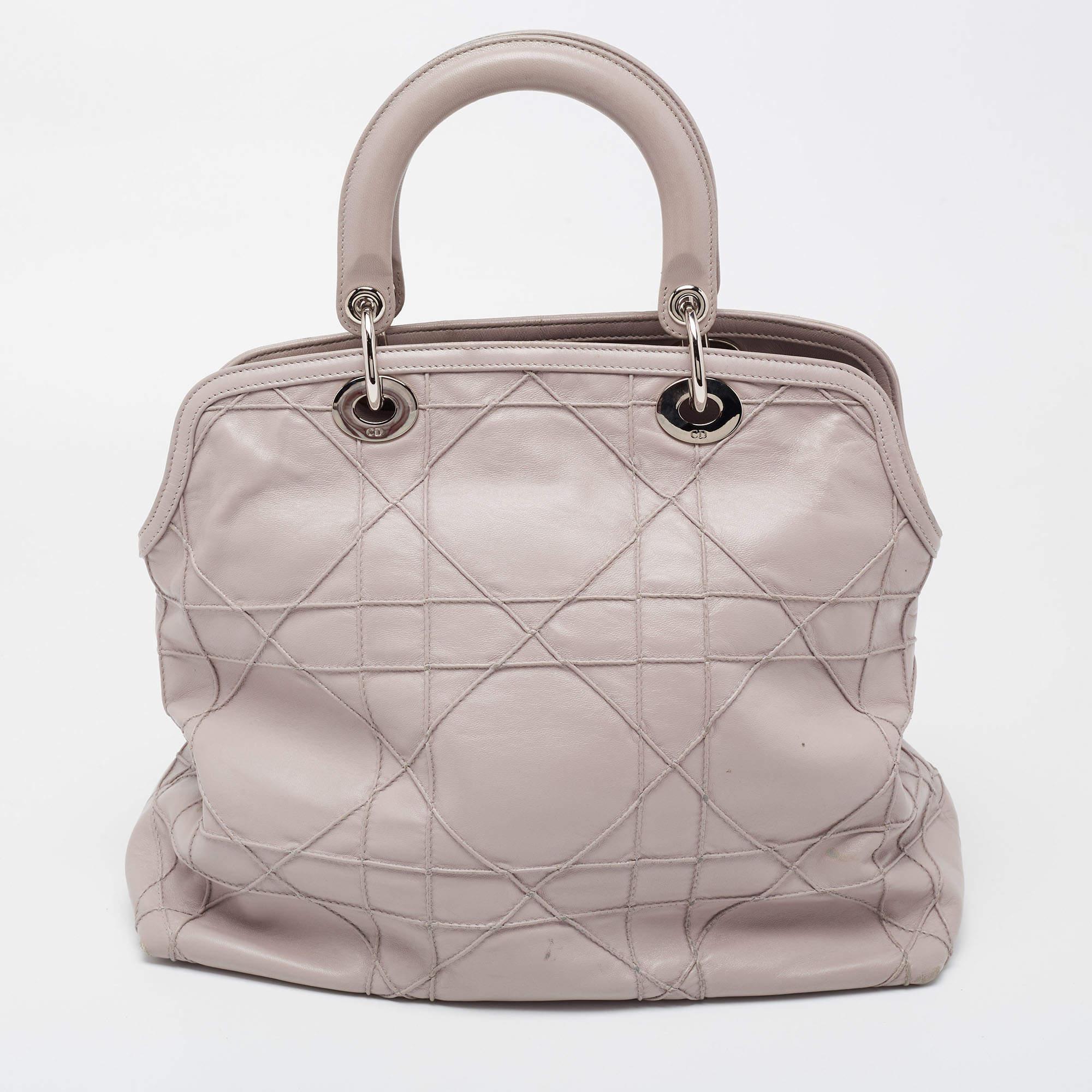 From the house of Dior, this stunning Granville tote is a true statement accessory. Arriving in Taupe leather, it gets a distinctive look with the signature Cannage quilt. It features double leather top handles and the dangling DIOR charms at the