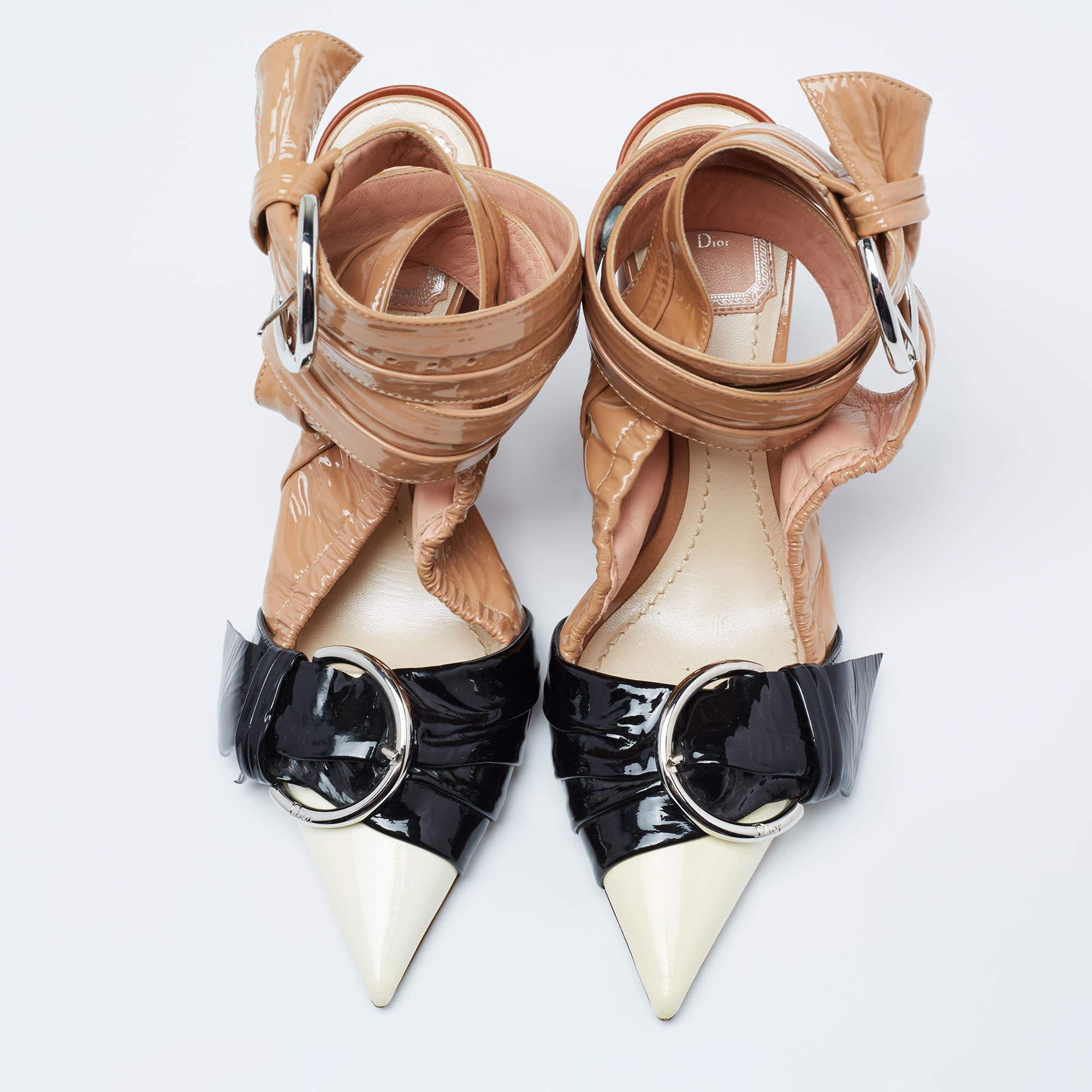 Diese Sandalen von Dior sind mit ihren avantgardistischen Details absolut umwerfend. Sie sind aus glänzendem Lackleder gefertigt und zeigen sich in mehrfarbigen Tönen, die einen mühelosen Stil ausstrahlen. Sie haben spitze Zehen, Schnallendetails