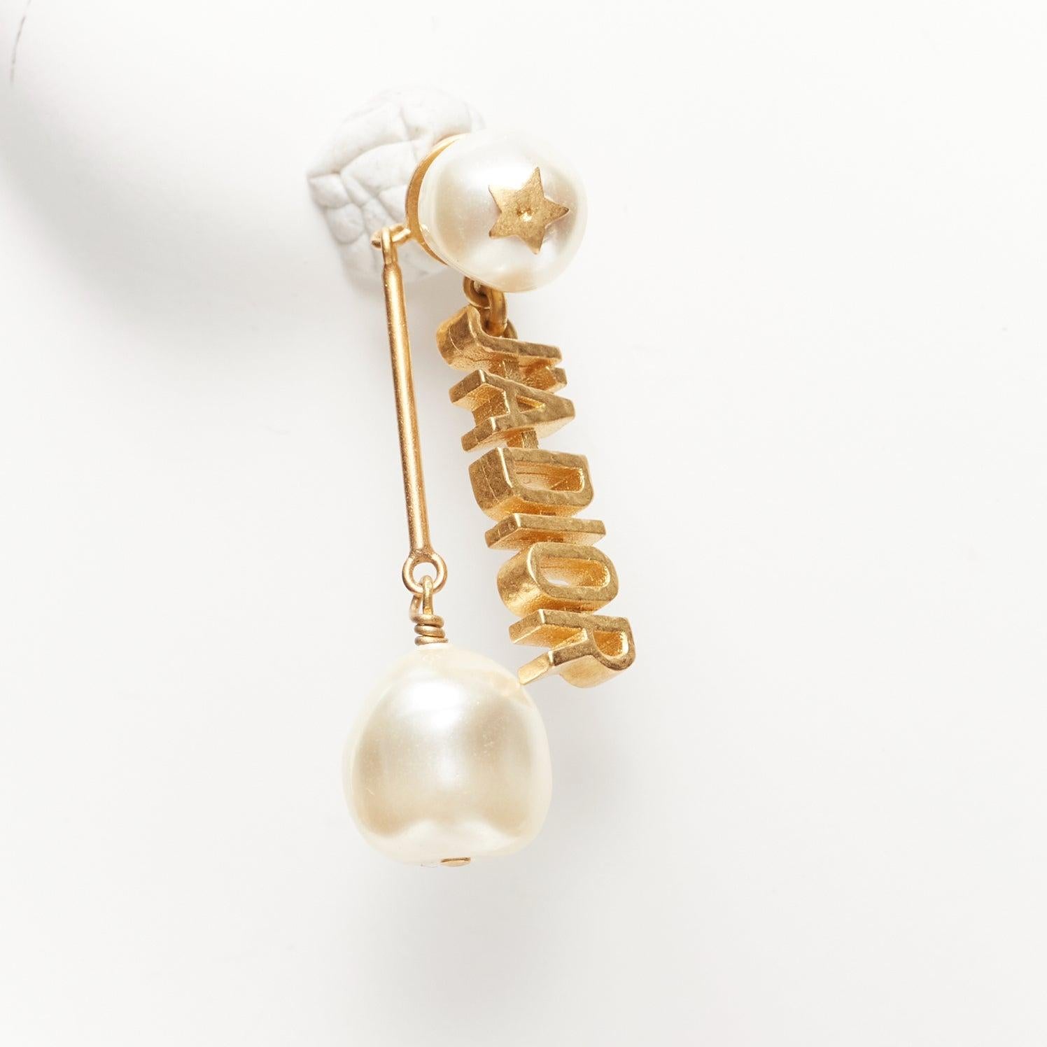 DIOR Tribale J'adior, paire de clous d'oreilles asymétriques en or avec fausse perle en forme d'étoile pendante en vente 1