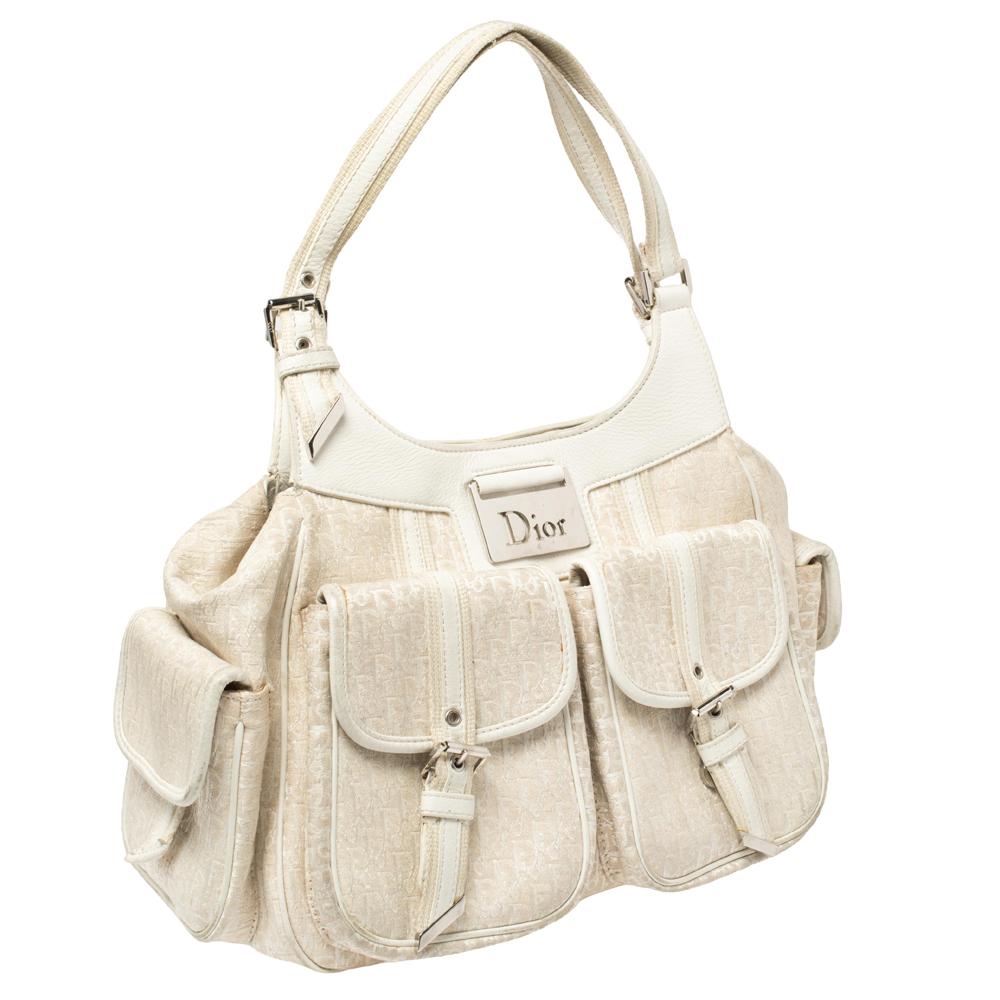 Diese modische und zugleich bequeme Tasche aus Canvas und Leder von Oblique bietet Platz für alles, was Sie brauchen. Diese vanillefarbene Tasche mit mehreren Außentaschen ist unbestritten stilvoll und brillant designt - da kann man nichts falsch