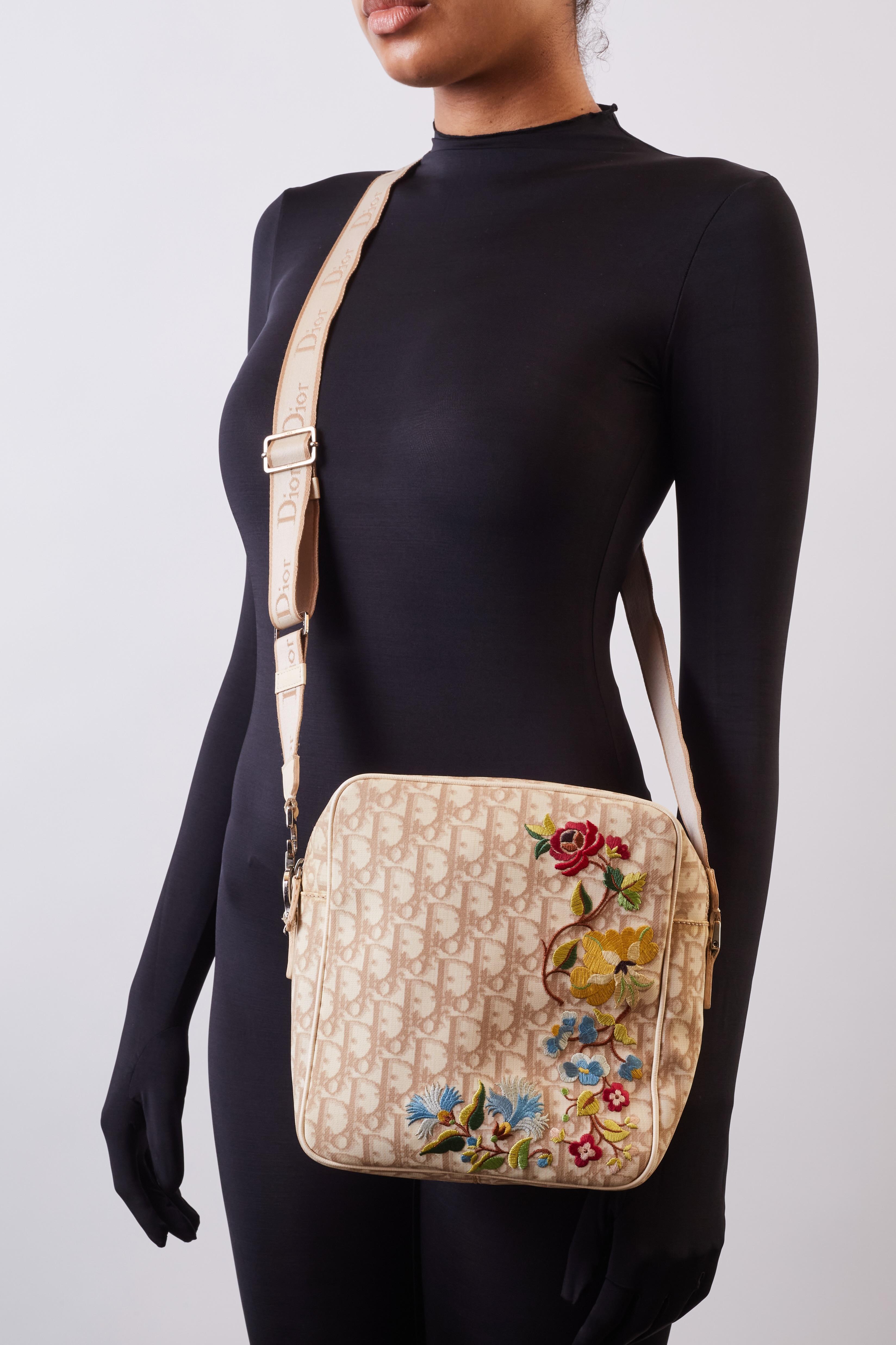 Dior vintage messenger bag designed by Galliano in 2004. Theban features Dior’s signature oblique monogram print, floral embellishment, a logo shoulder strap, top zip closure and nylon lining. 

Color: Beige
Material: Coated canvas
Date Code:BO D