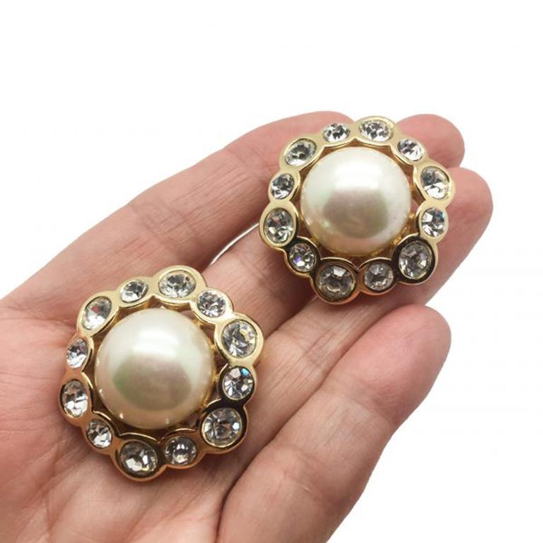 Une pièce classique de la joaillerie Dior qui respire le glamour intemporel. Ces boucles d'oreilles vintage en perles Dior présentent une merveilleuse demi-perle entourée des plus captivants strass Swarovski. Le tout est serti dans un métal