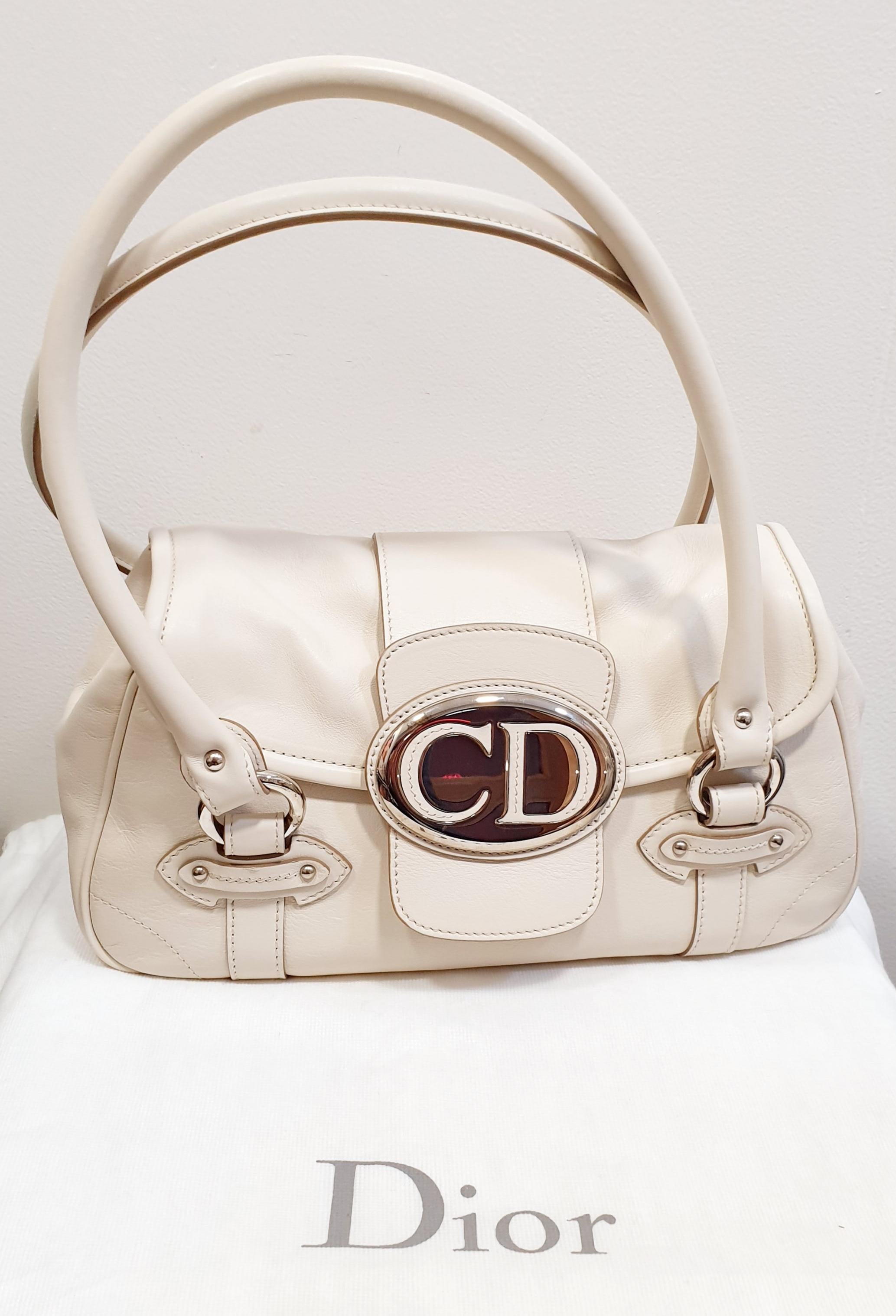 This Christian Dior bag is made with white leather , large CD logo plaque in sliver tone on the front, silver-tone hardware accents, snap closure and a light brown diorissimo fabric-lined interior with a zipped pocket.

Designer Christian Dior
Brand