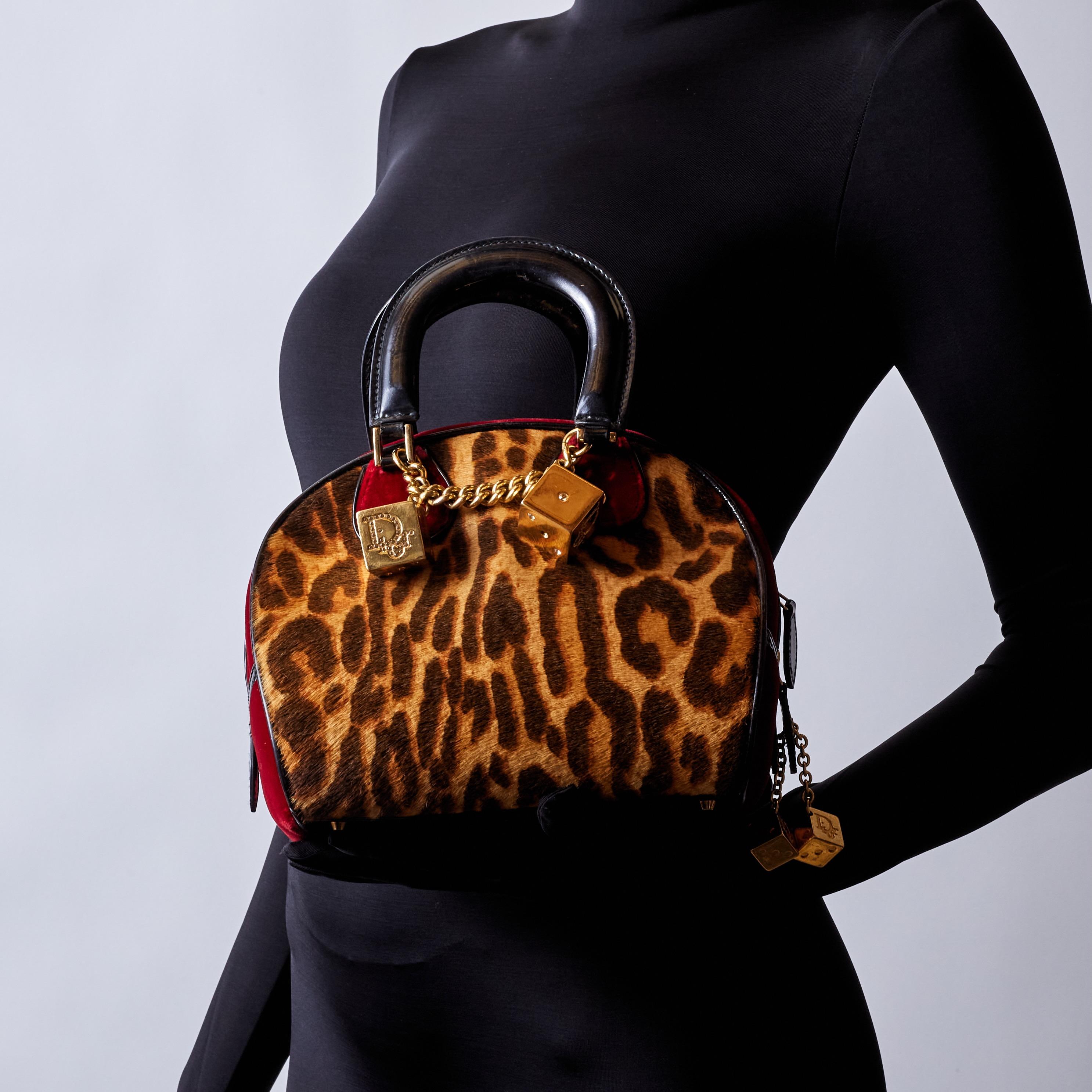 DIOR VINTAGE LEOPARD PRINT GAMBLER DICE BOWLER BAG MINI

This vintage bowler style bag is from the 2004 Collection by John Galliano. The bag features brown pony hair, leopard print, gold-tone hardware, leather & patent leather trim, chain-link