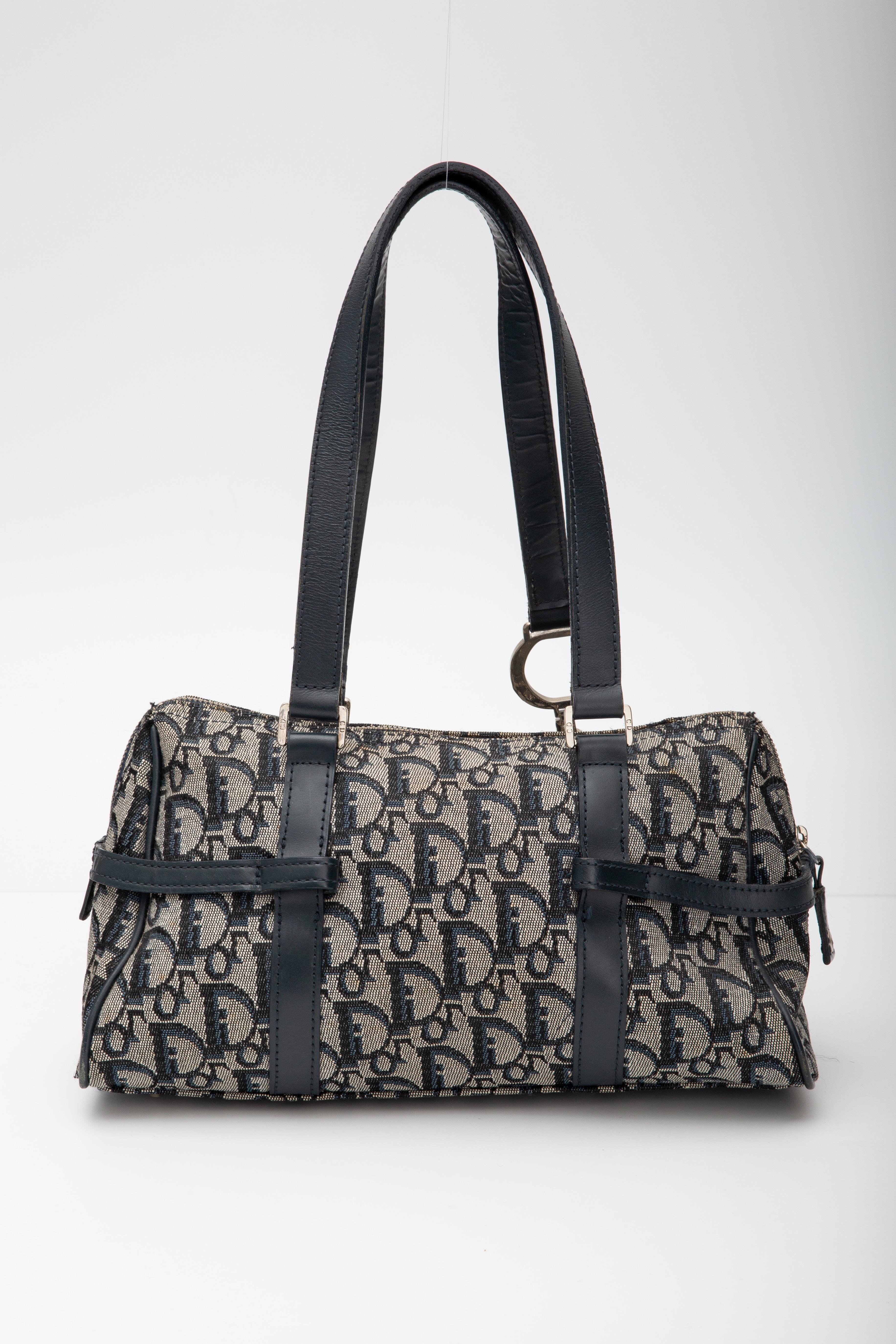 This vintage Dior Boston style bag is made with navy canvas with Dior’s signature monogram oblique/trotter print. The bag features dual flat leather top handles, top zip closure, leather details, logo charms and blue interior lining.

COLOR: