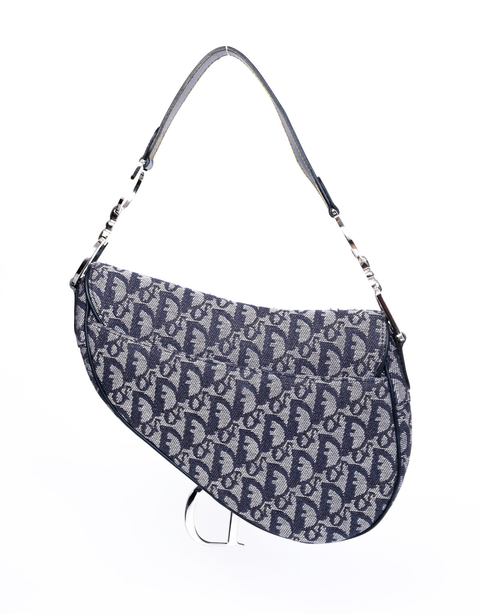 Esta silla icónica de Dior está confeccionada con lona azul marino con el estampado del monograma de Dior. Con una correa desmontable y ajustable con enganches de eslabones en forma de D y C para la correa, un colgante con el logotipo 