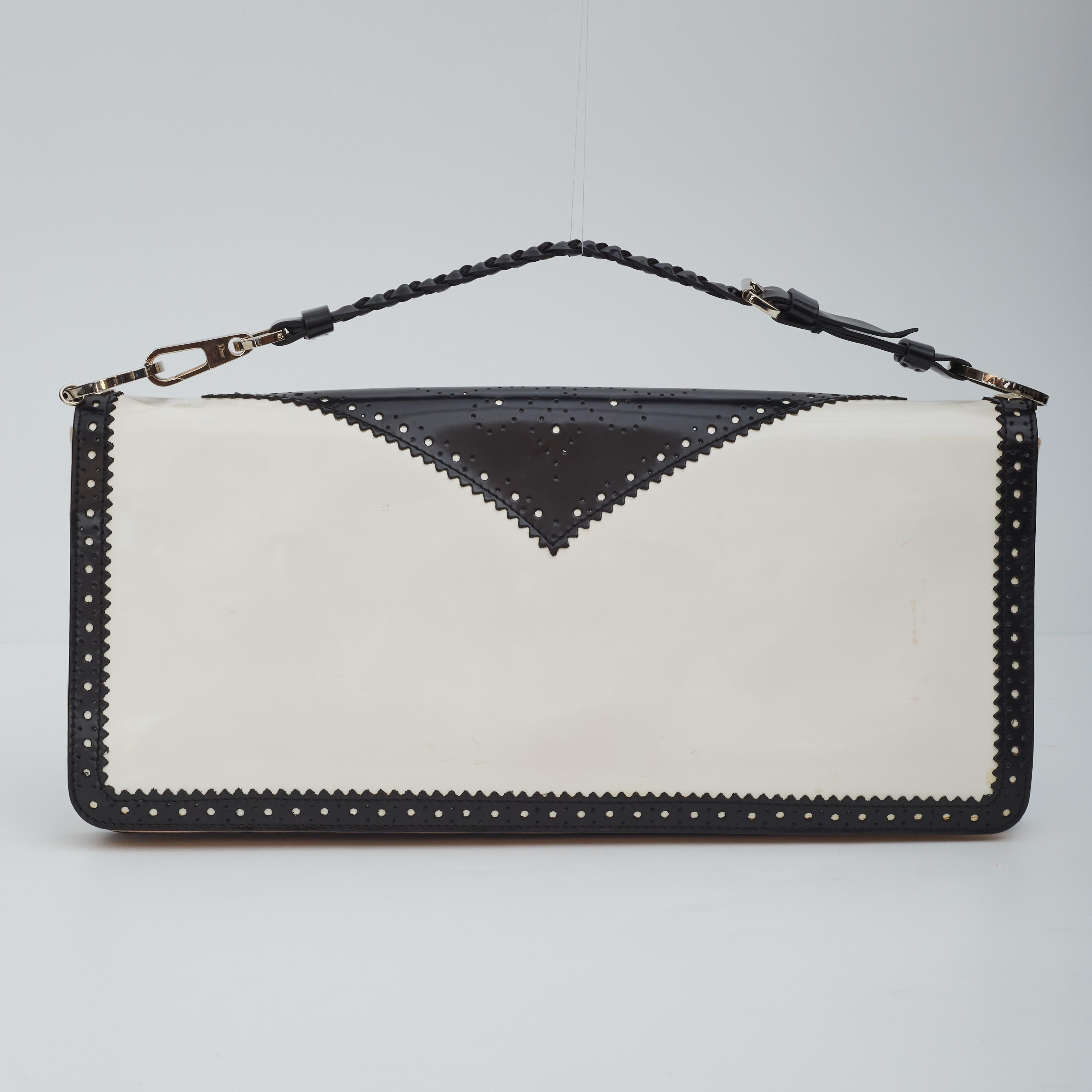 Dior bag from the art-deco D-TRICK series in black and white patent leather with silver metal hardware. Interior linking is silk with a p pocket inside with a mirror.
Black Dior logo lining 

Color: Black and white
Material: Patent leather
Item