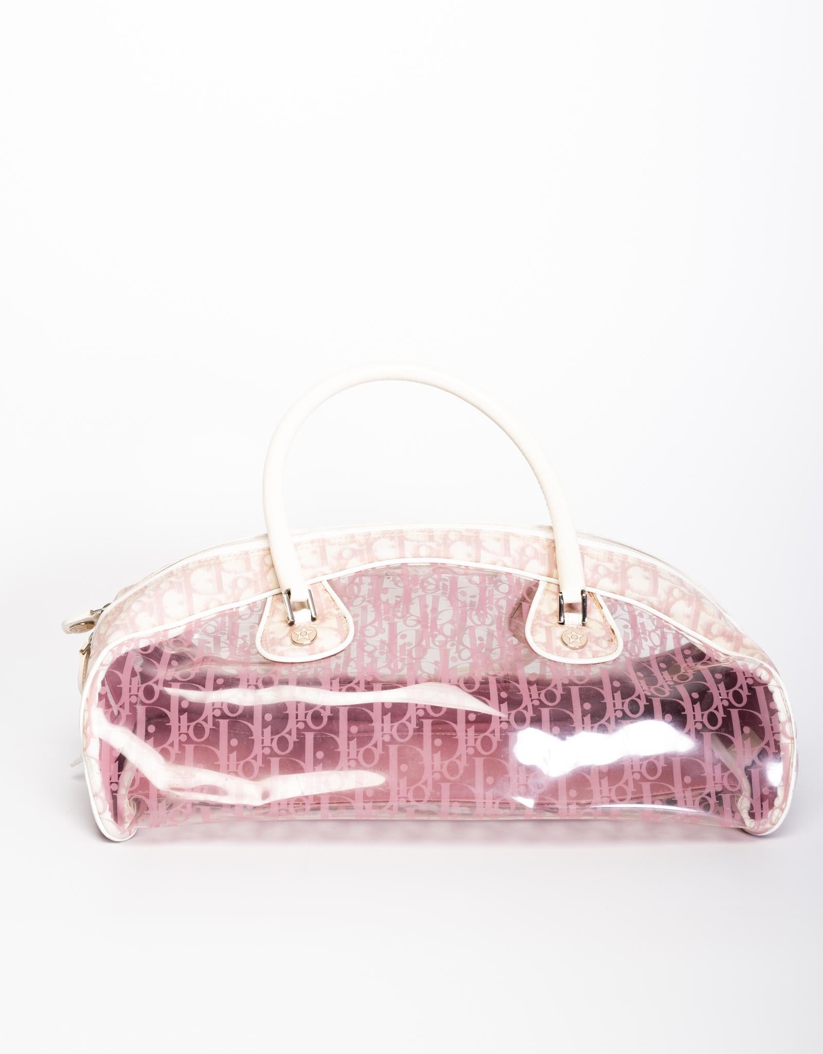 Diese rosafarbene Trotter Bowler-Tasche von Dior ist außen mit Dior Monogram Canvas, transparentem PVC, Lederoberflächen, zwei großen Looping-Griffschlaufen, einem Reißverschluss an der Oberseite und goldfarbener Hardware ausgestattet.

FARBE: Weiß