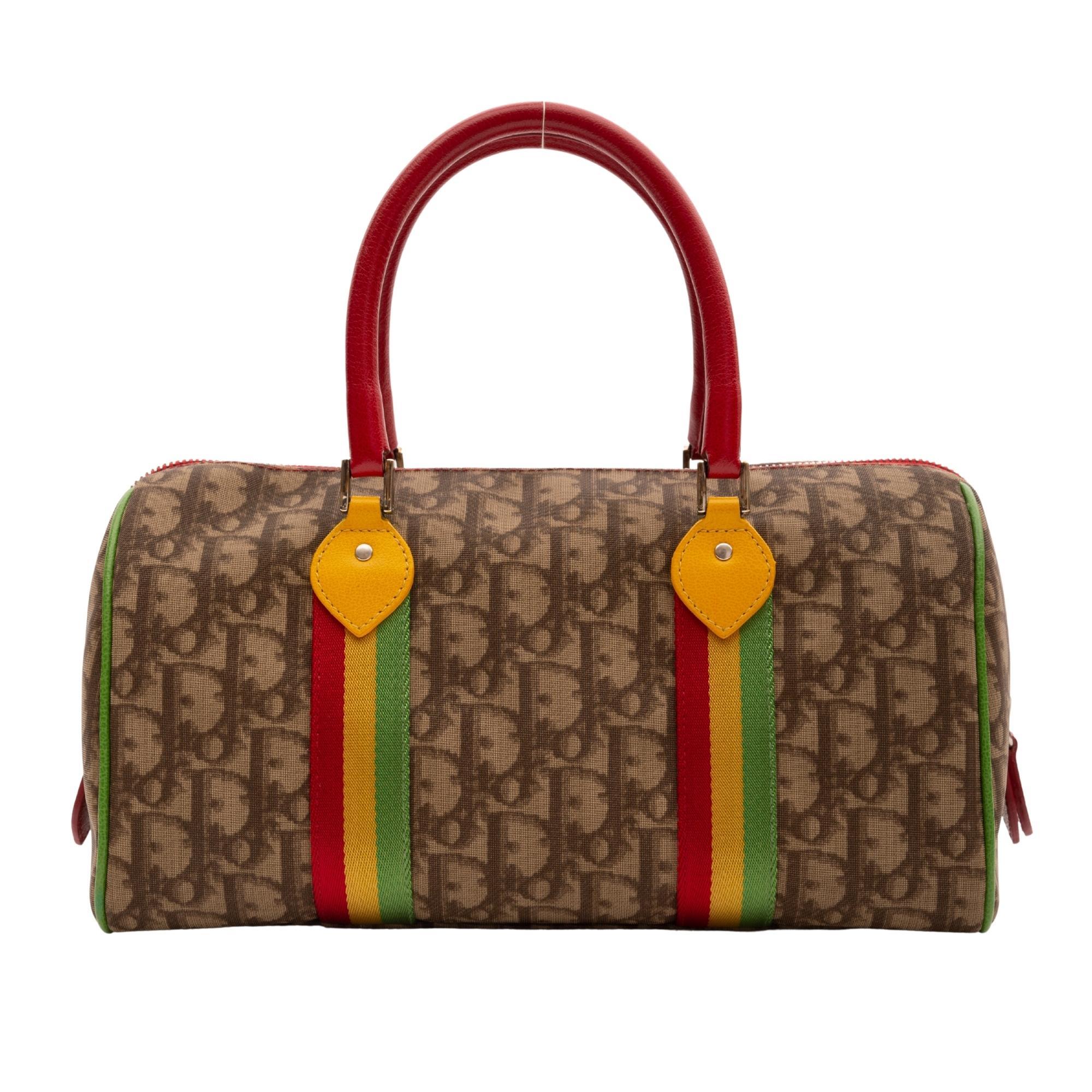 Christian Dior Boston bag from the early 2000's Rasta collection made of coated canvas with Dior’s signature monogram trotter print. The bag features Rasta inspired colors on leather details including dual rolled leather top handles in red, front