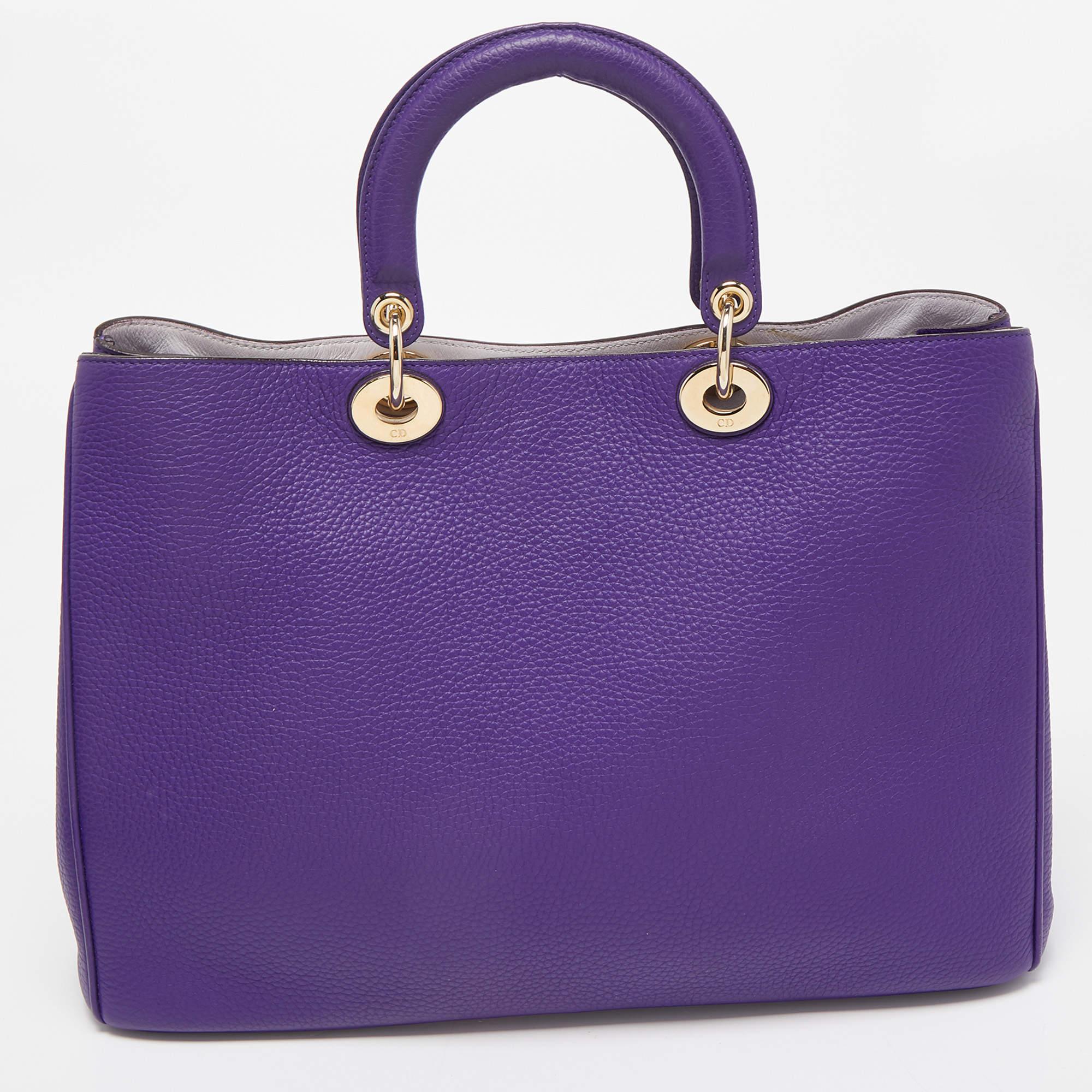 This Diorissimo Shopper tote from the House of Dior will help you keep your belongings safely and stylishly. It is made using leather on the exterior and is highlighted with D.I.O.R charms on the front. It features dual handles, a shoulder strap,
