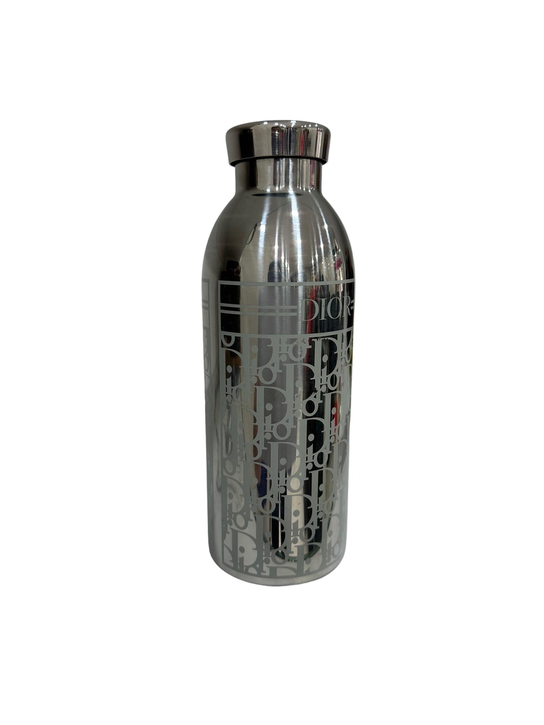 Dior signed bottle, made of silver-colored stainless steel with oblique white jacquard pattern. Equipped with a special isothermal technology that keeps drinks hot for 12 hours and cold for 24. It is in excellent condition.