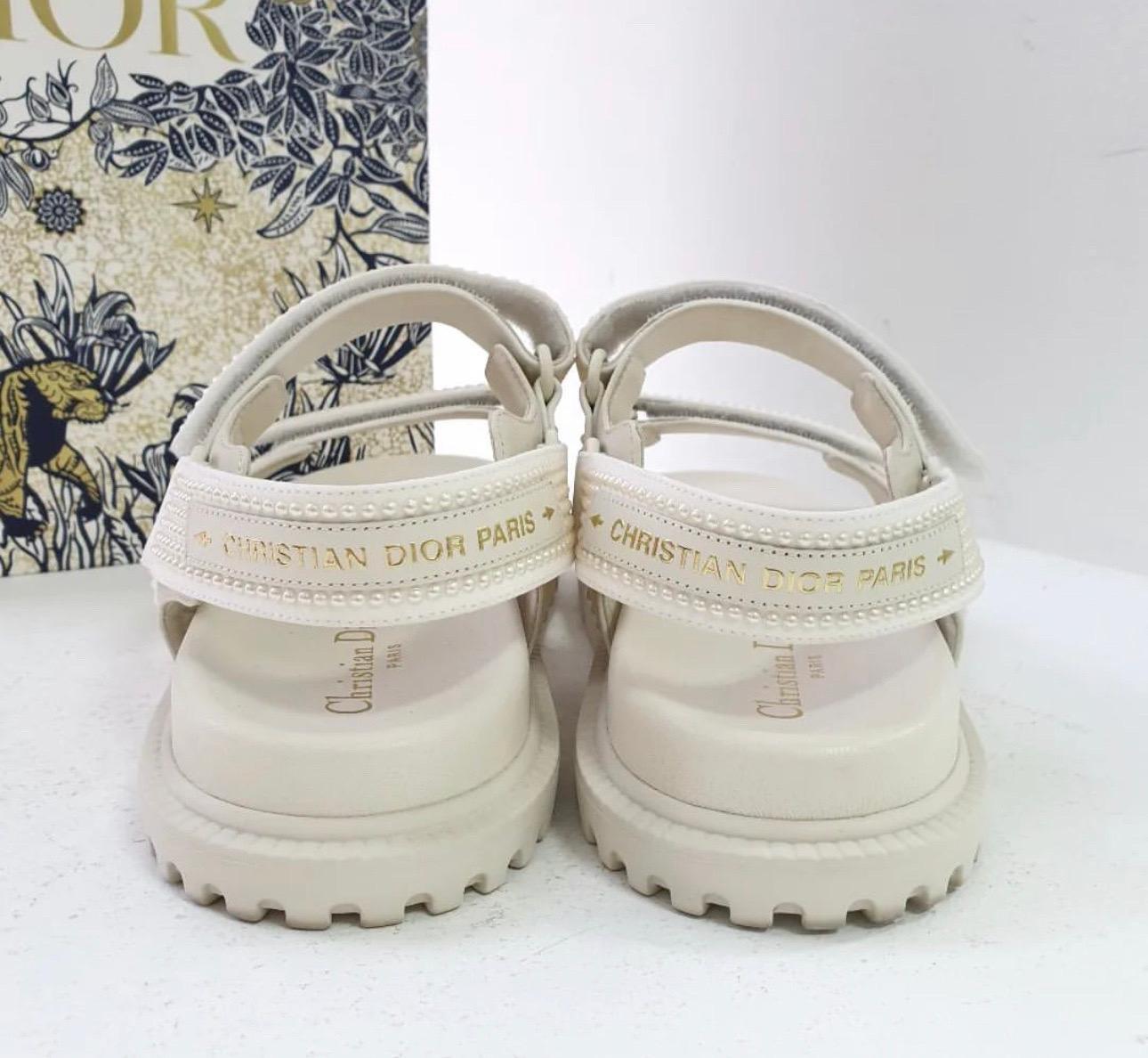 Dioract Leather Sandal in white leather with pearl stud embellishments 
Adjustable straps with Velcro closures 
Smooth leather insole 
Rubber sole with traction
Sz.39
No box. No dust bag