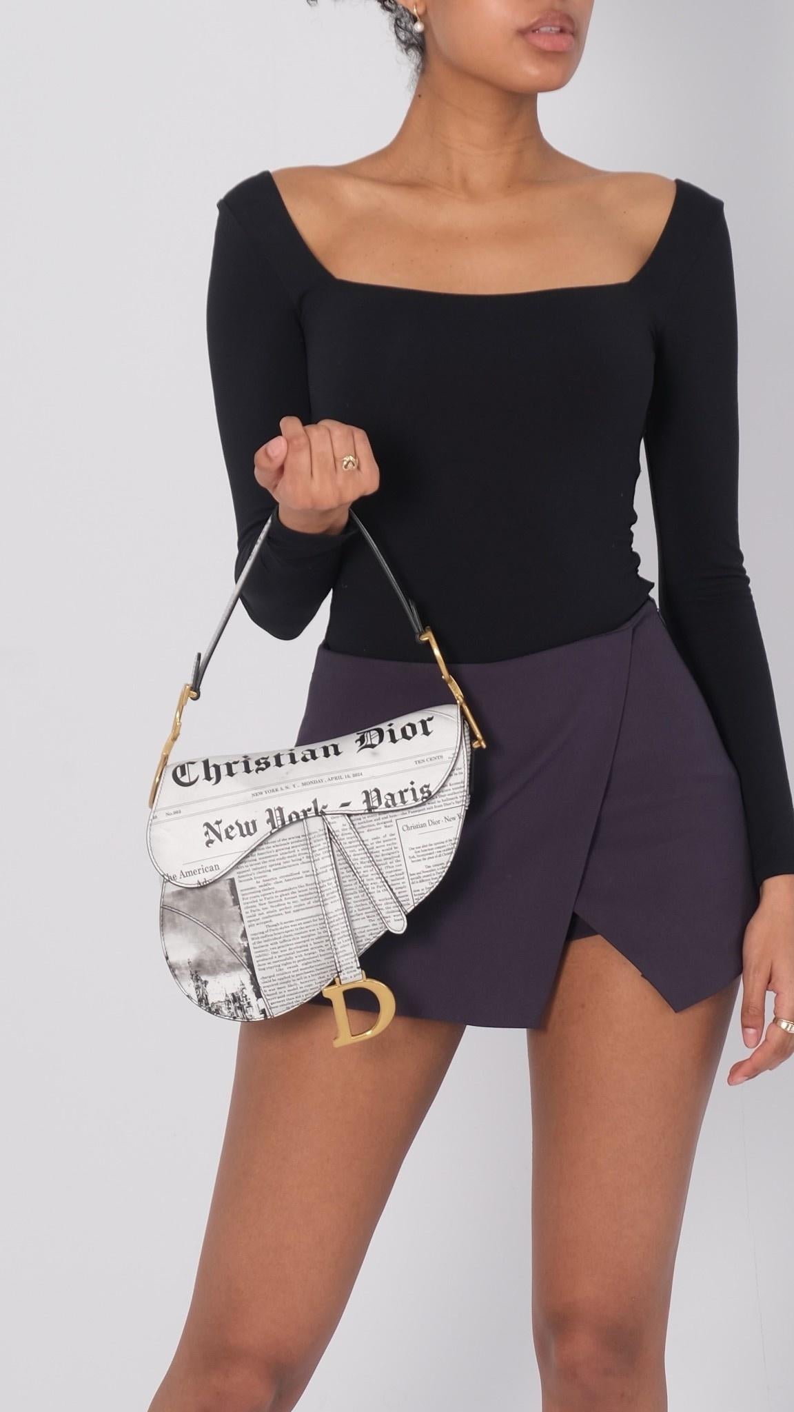 Maria Grazia Chiuri brings a fresh update to the iconic Saddle bag. Constructed in calfskin, it showcases the white and black Newspaper motif inspired by House archives. The legendary design features a Saddle flap with a D stirrup strap and magnetic