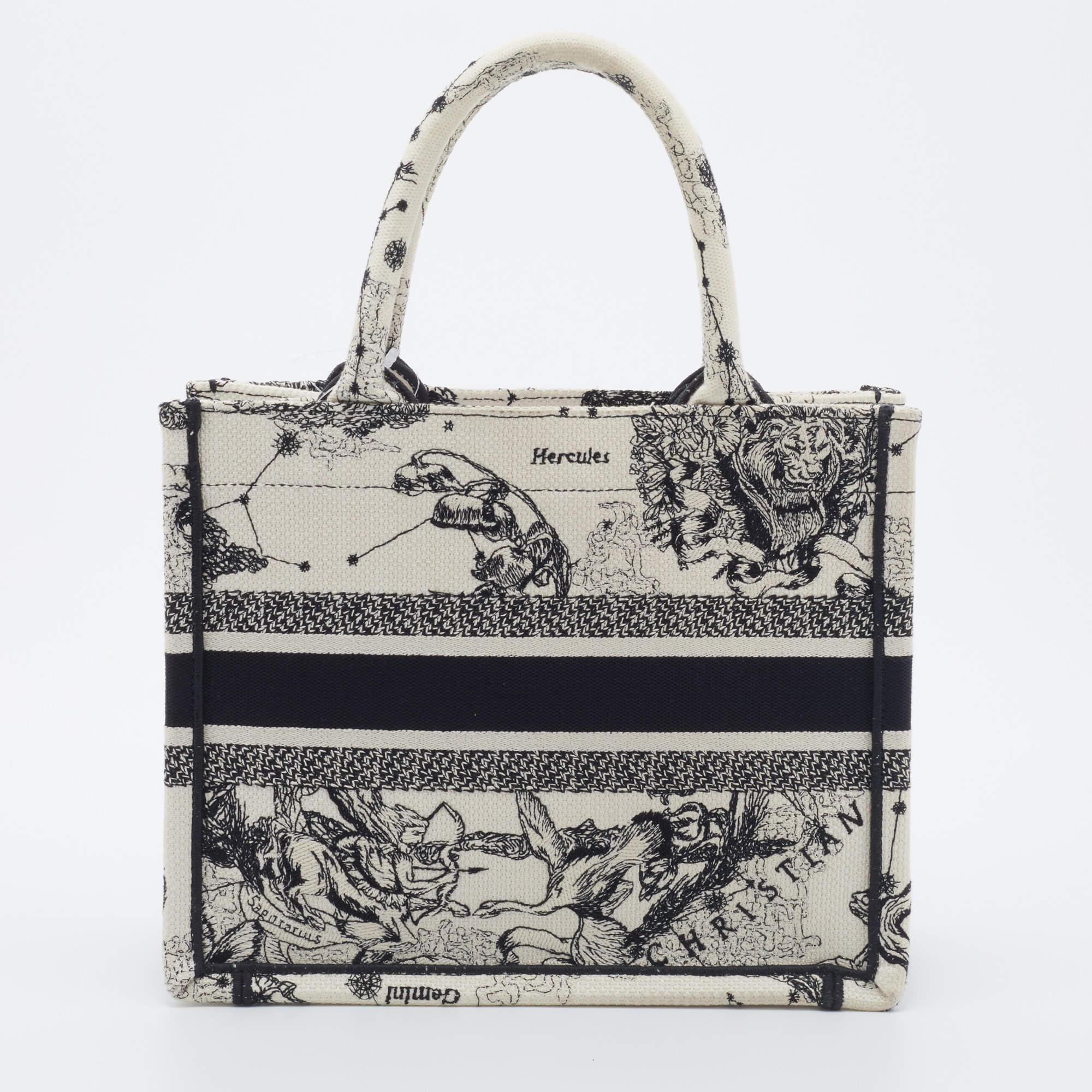 Designed by Maria Grazia Chiuri, the Dior Book Tote is a coveted travel accessory for people with style. The small Book tote here is crafted using canvas into a beautiful structure and covered in the Zodiac Embroidery Hercules motif all over. Two