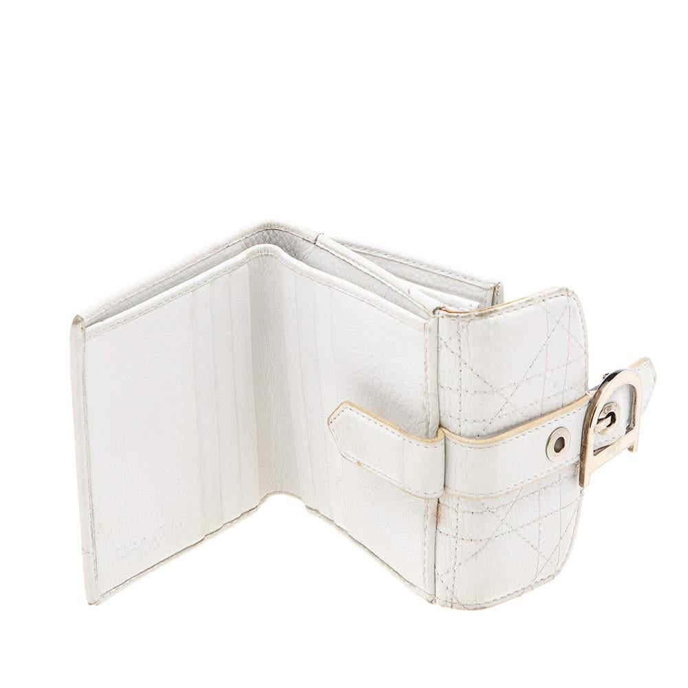 ¡Procedente de la Casa Dior, esta cartera francesa es un accesorio con clase que tienes que tener ya! Está diseñado con cuero Cannage blanco, con un colgante en forma de D adornando la parte delantera. Alberga un pulcro interior de tela y cuero y