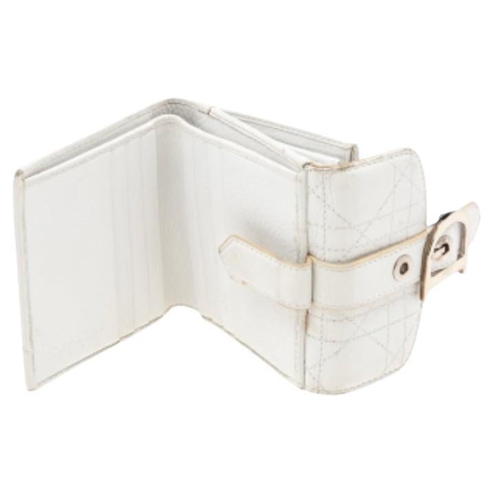 Coming from the House of Dior, this French wallet is a classy accessory you need to own now! It is designed using white Cannage leather, with a D charm embellishing the front. It accommodates a neat fabric-leather interior and shows silver-tone