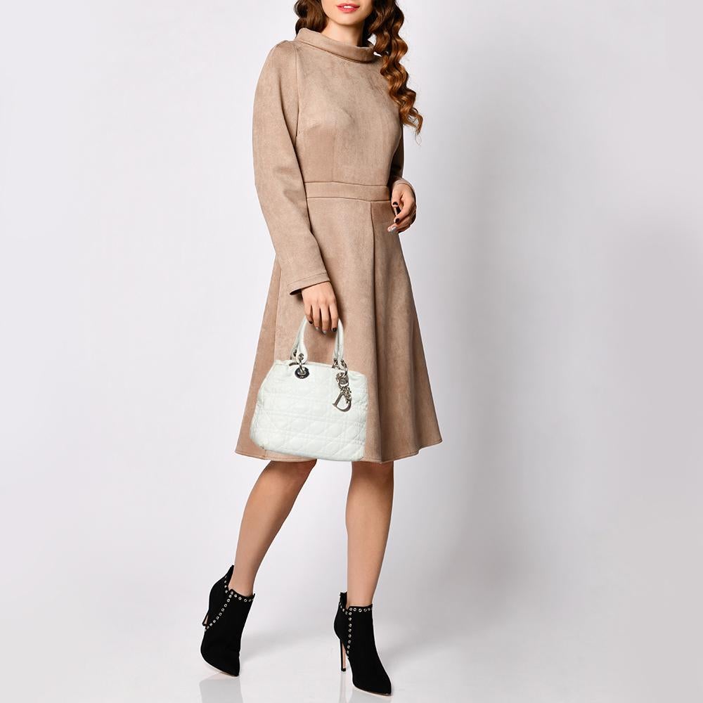 Die Lady Dior Tote ist eine Kreation von Dior, die weltweit Anerkennung gefunden hat und heute eine begehrte Tasche ist, die jede Fashionista unbedingt haben möchte. Diese weiße Tote ist aus weichem Leder gefertigt und trägt das charakteristische
