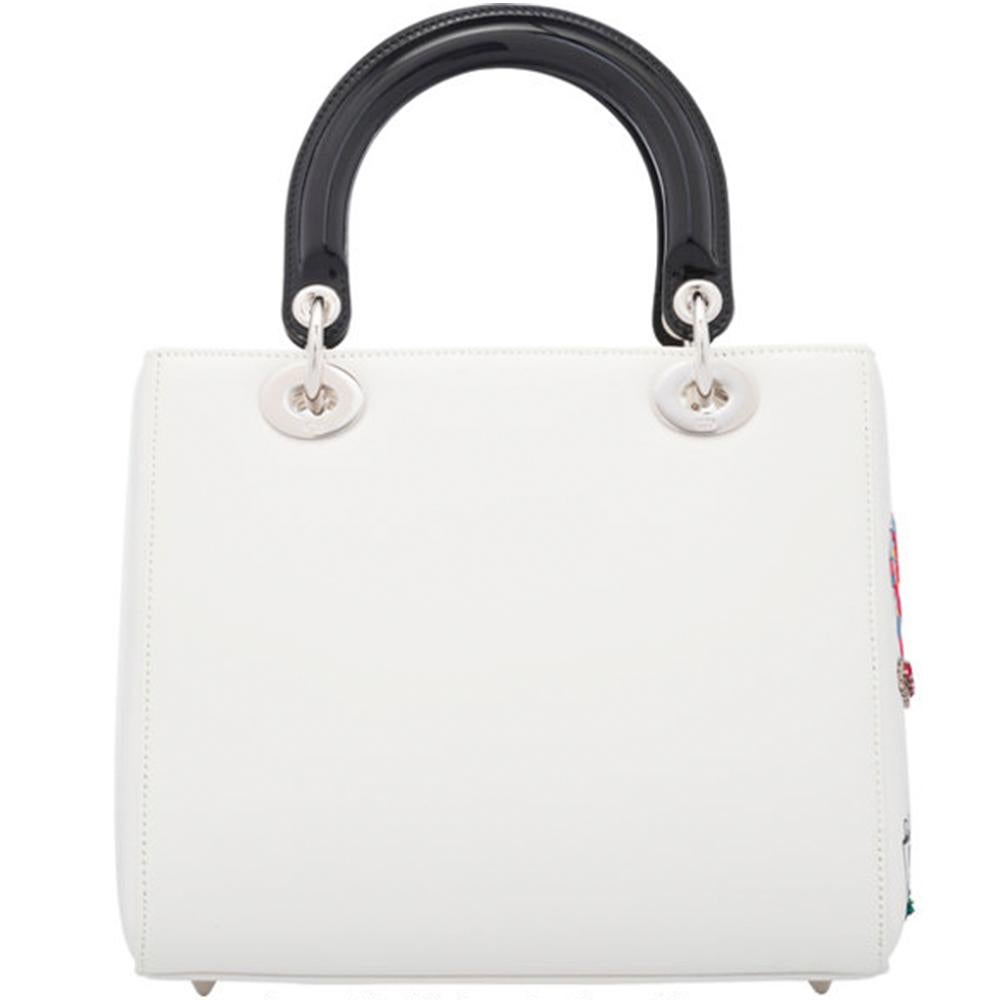 This Lady Dior bag, the symbol of Couture elegance and refinement is elegantly crafted in a soft and radiant white lambskin leather and features a vibrant, embroidered Eiffel Tower design, which draws its inspiration from Christian Dior's love of