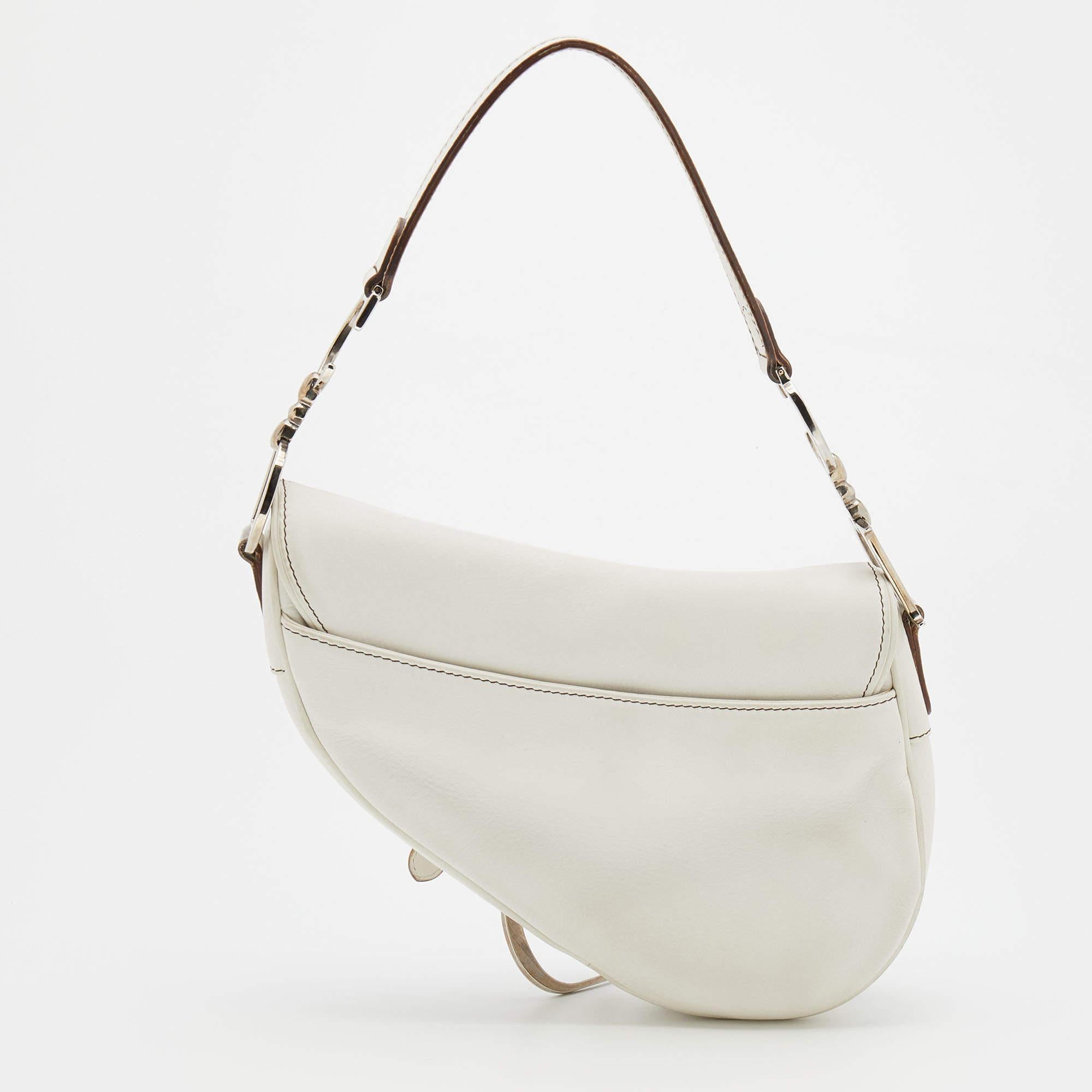From the house of Dior, this Saddle bag is an excellent blend of elegance and style. It comes in a white hue that is perfect for making a summer statement. The bag is crafted from leather and features a shoulder strap and a well-sized interior. Make
