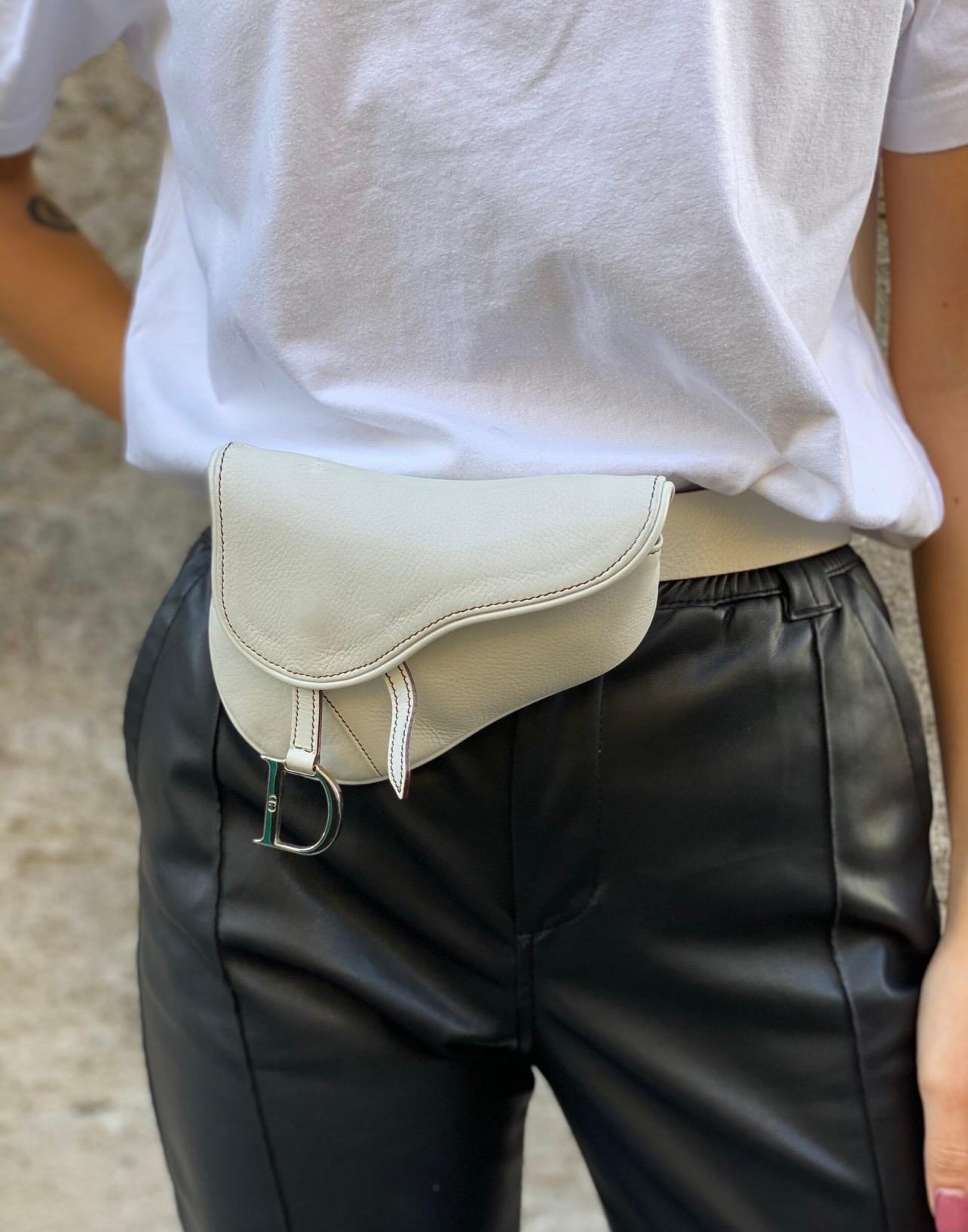 Dior Saddle mini in white leather with silver hardware.  It has an adjustable and removable shoulder strap.  Front flap closure with magnetic button.  Brown canvas interior with Dior jacquard print.  Condition of the saddle very good, as can be seen