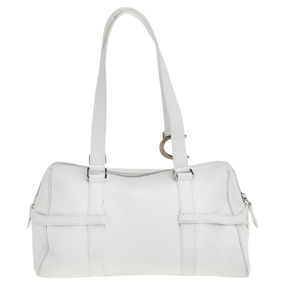 This stylish Boston bag by Dior has been crafted to assist you with ease and style on all days. It is crafted from white leather and is accented with logo charms. The bag features dual top handles and a spacious interior.