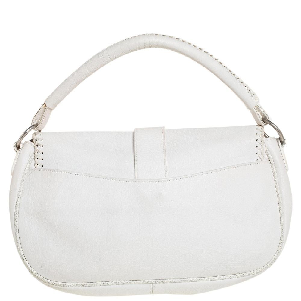 From the house of Dior, this Gaucho hobo is an excellent blend of elegance and style. It comes in a white hue that is perfect for making a statement. The bag features a chunky buckle with an attached key on the front flap and a fabric-lined