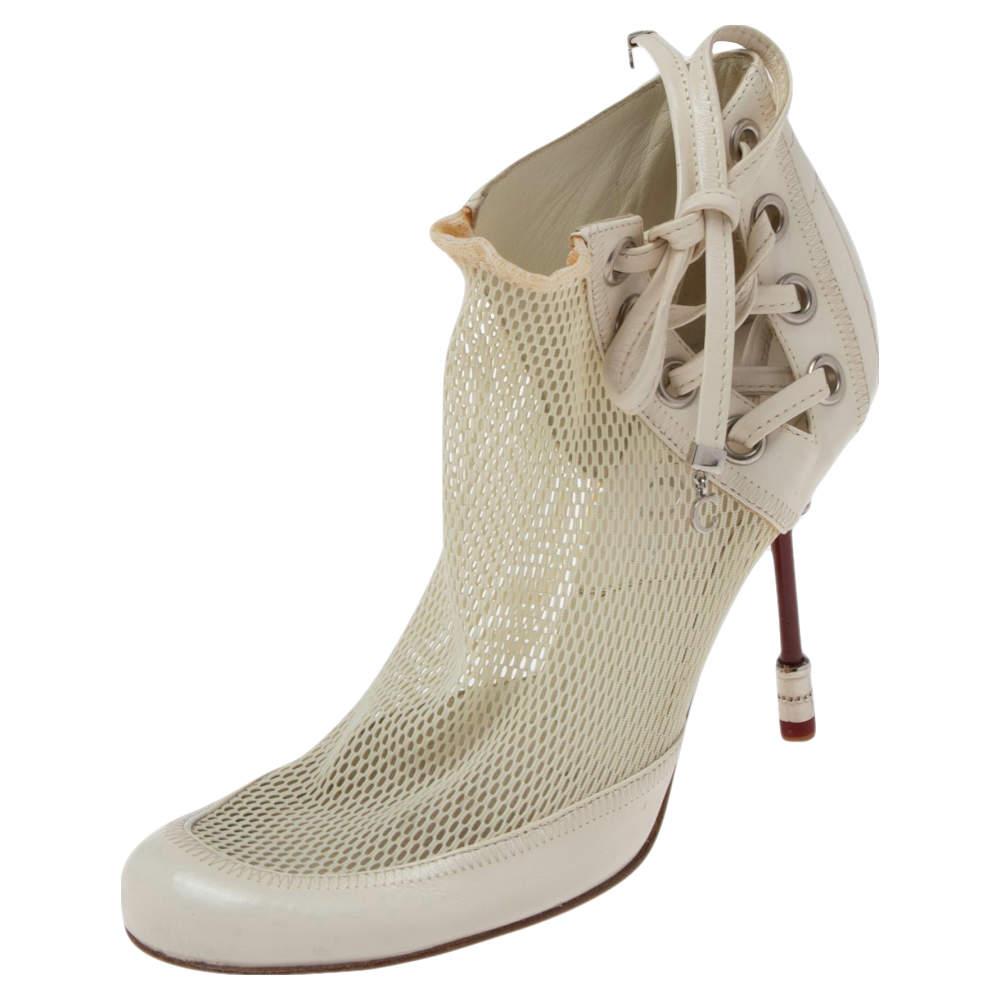 Coming from the House of Dior, these boots will grant your feet timeless elegance and excellence. They are made from white net and leather into an ankle-length silhouette. They flaunt silver-toned hardware, lace-up fastenings, and 10 cm heels. Add