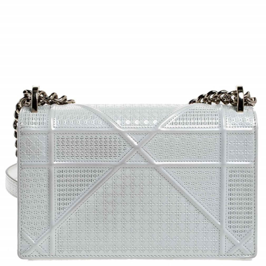 This Diorama bag is simply breathtaking! From its structured shape to its artistic craftsmanship, the bag sweeps us off our feet. It has been crafted from white patent leather and covered in the brand's signature Cannage pattern. A gold-tone closure