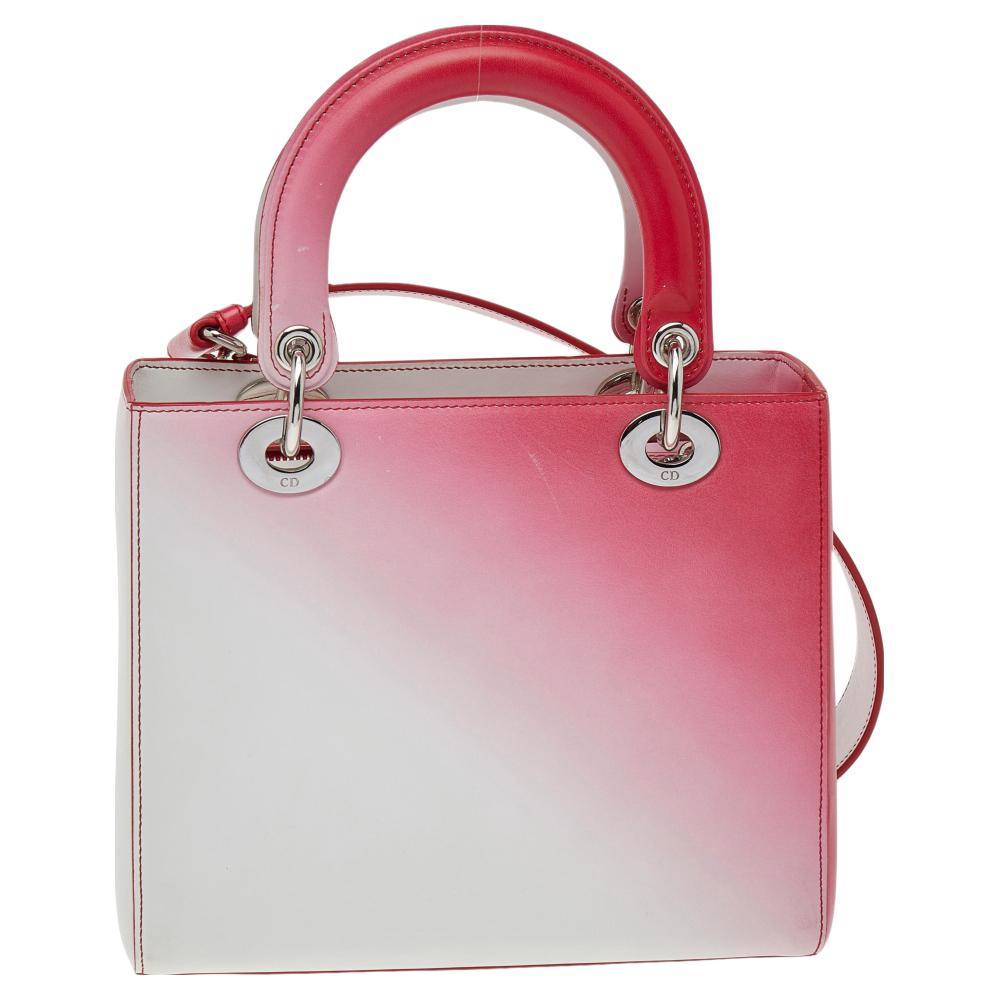 This sophisticated and feminine Lady Dior tote in your hand is apt for the perfect Dior look. Crafted from leather, this white & pink tote features a gradient print and flaunts the signature Dior charms, two round handles, a detachable shoulder