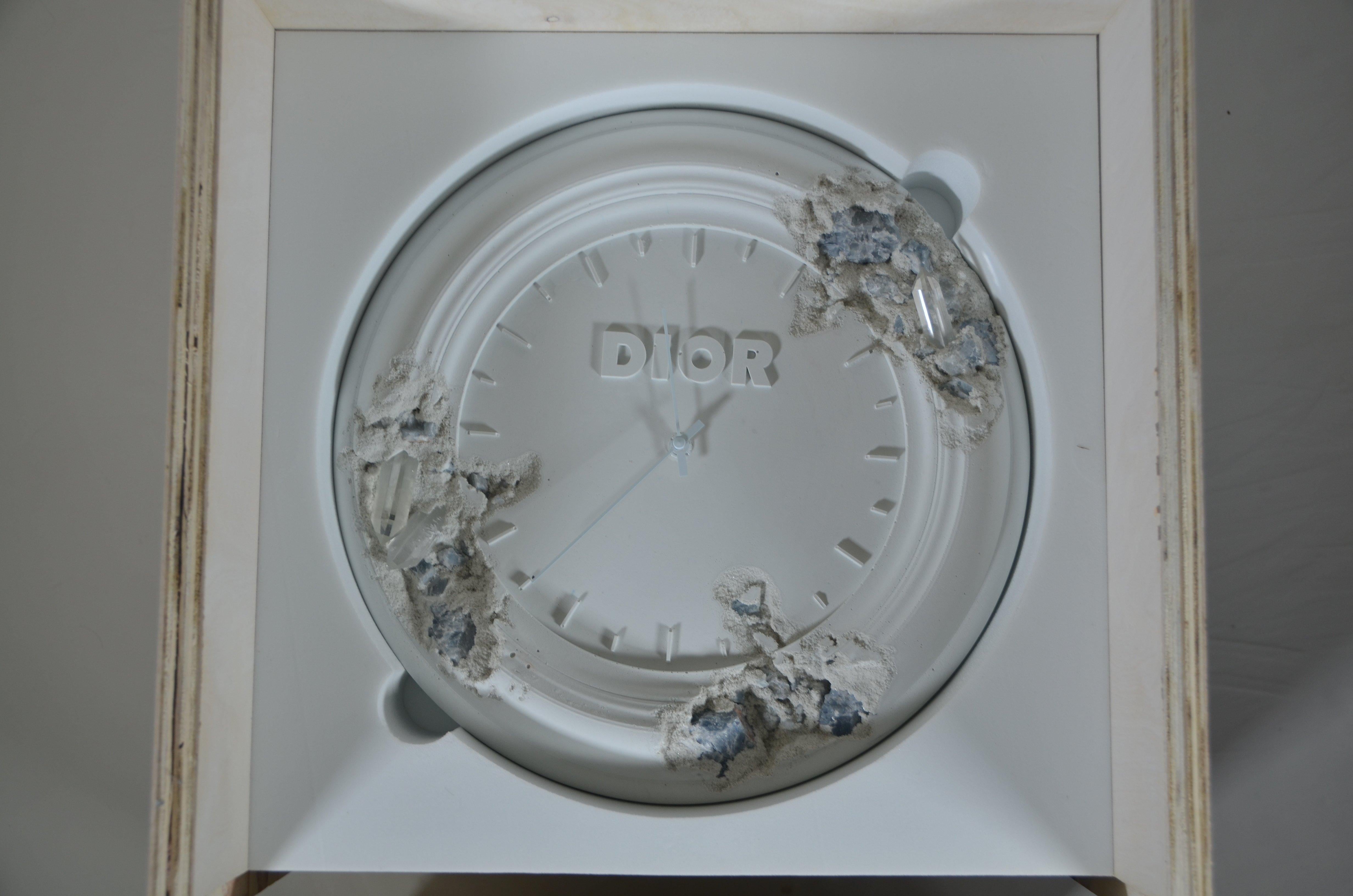 Summer 2020 Men’s show, Daniel Arsham has transformed Christian Dior’s atelier clock into a functional sculpture.  
Eroded in several places as if ravaged by time, this veritable work of art emblazoned with the Dior signature reveals cracks pierced