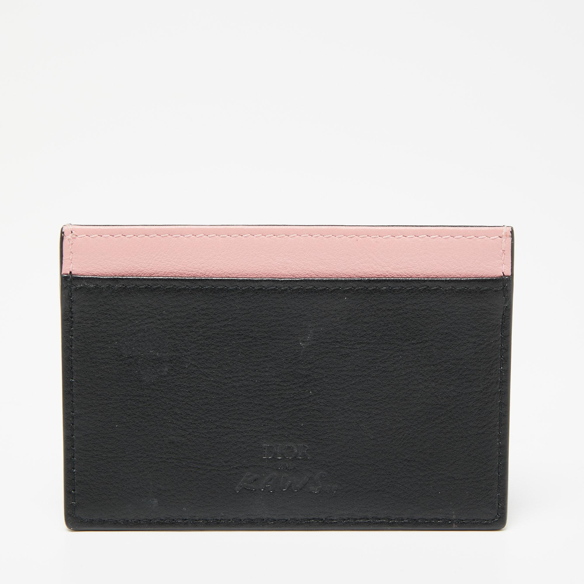 Stacked with bee detailing and crafted into a sturdy shape, this Dior x Kaws cardholder is a luxurious accessory you need to own today! It is made using black and pink leather and is equipped with ample slip pockets.

Includes: Original Box
