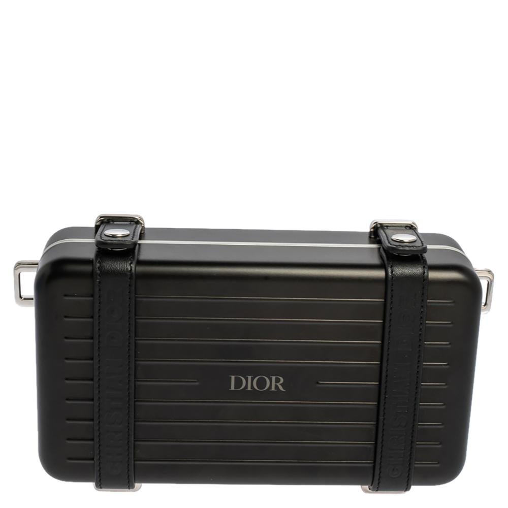 Die persönliche Clutch stammt aus einer besonderen Zusammenarbeit zwischen DIOR und RIMOWA. Die aus leichtem Aluminium gefertigte Kupplung hat eine kompakte Größe:: so dass sie ideal in der Hand getragen werden kann. Die Lederriemen mit Druckknöpfen