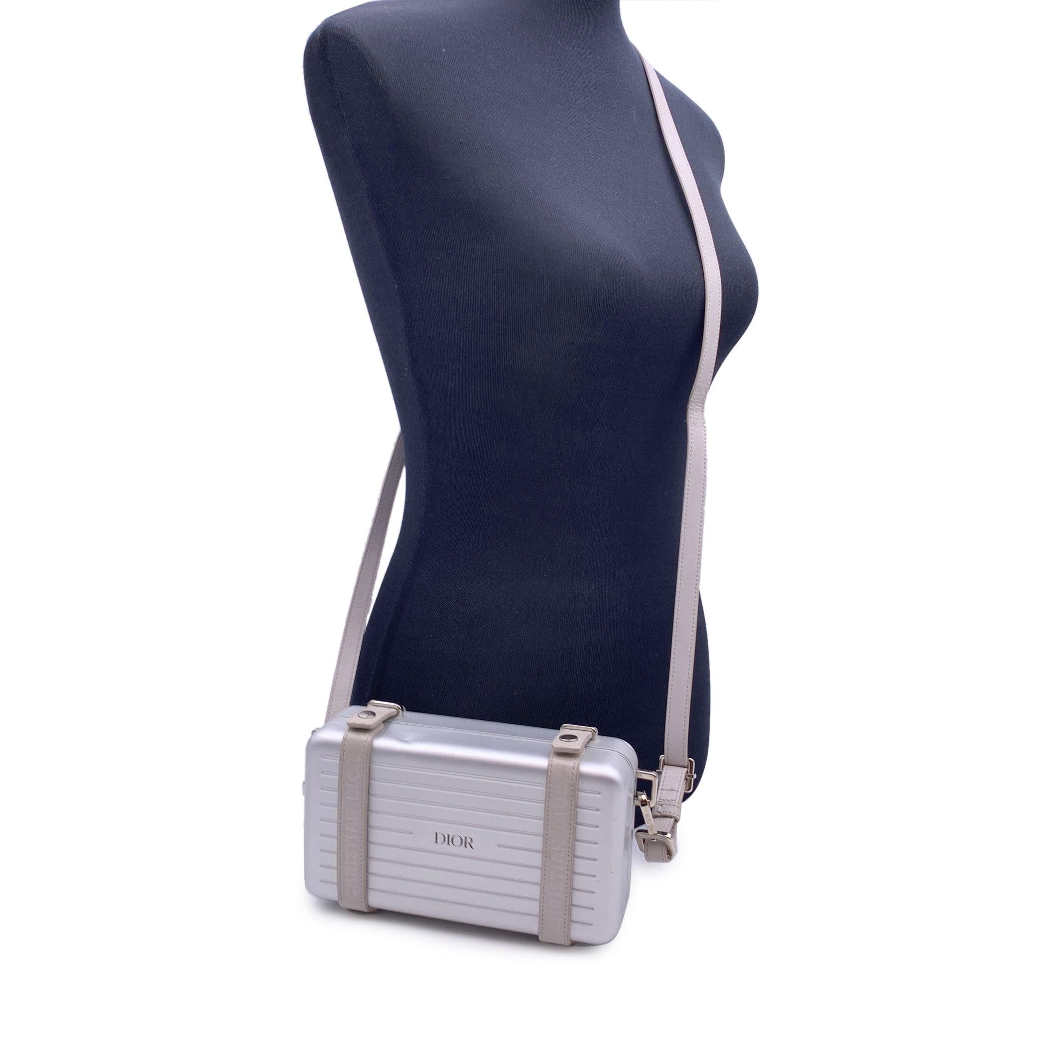 Diese wunderschöne Tasche wird mit einem Echtheitszertifikat geliefert, das von einer dritten Partei ausgestellt wurde. Das Zertifikat wird ohne weitere Kosten zur Verfügung gestellt DIOR X RIMOWA 'Personal Clutch' Crossbody Bag aus silbernem
