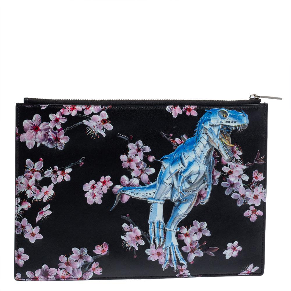 This pouch from Dior x Sorayama has been made using quality leather in Italy. It has a beautiful exterior and a nylon-lined interior that is secured by a top zip closure. This black pouch is adorned with cherry blossoms and Tyrannosaurus on the