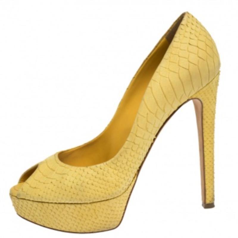 Mit diesen Pumps von Dior ziehen Sie die Blicke auf sich, wenn Sie herumlaufen. Das Paar aus gelbem, pythongeprägtem Leder hat ein Plateau, eine feminine Peep-Toe-Zehe und einen 13,5 cm hohen Absatz. Mit den Markeninitialen auf den Zählern sind