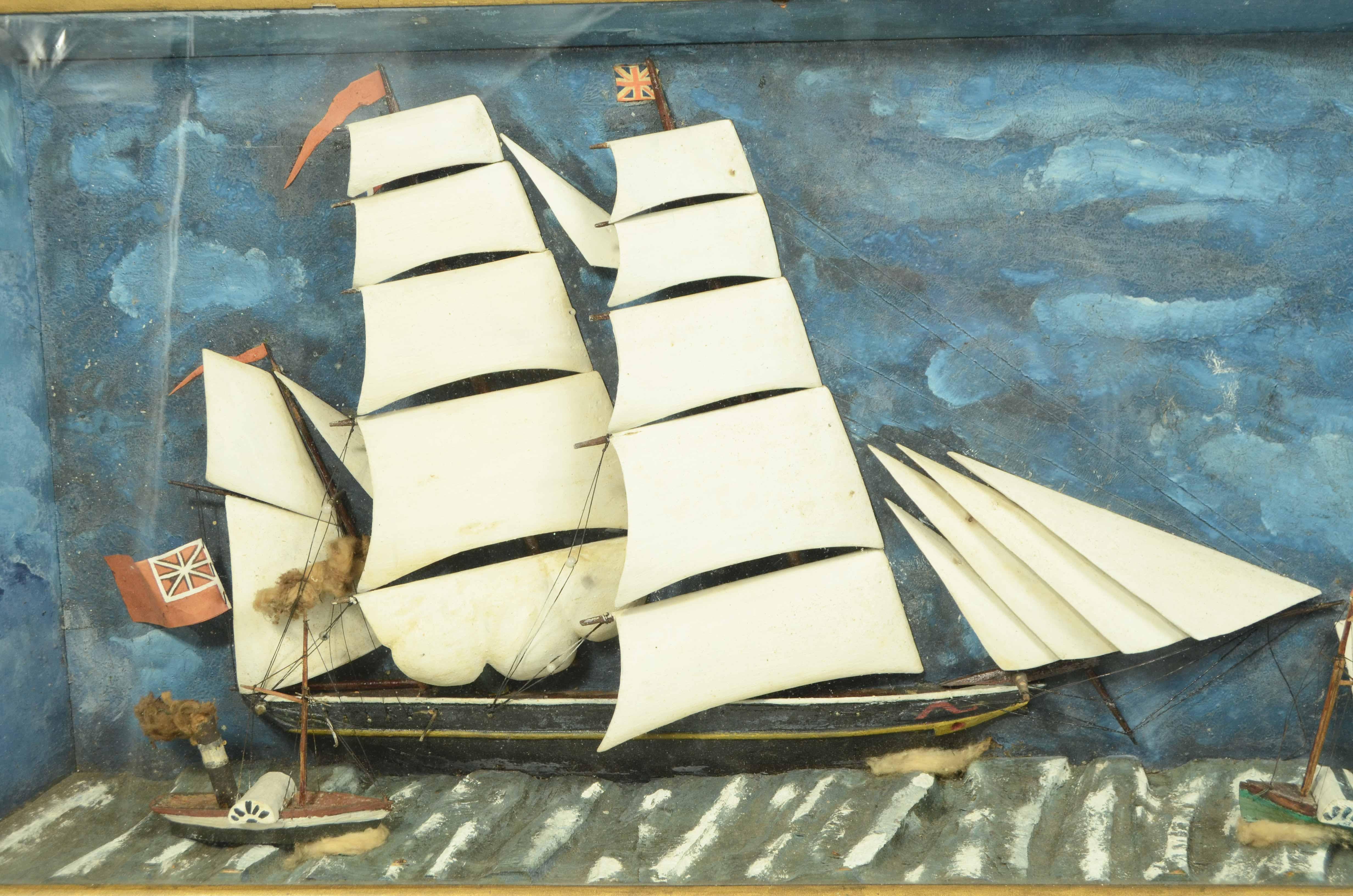 Diorama nautico in teca di legno e vetro dalla forma piramidale raffigurante mezzo scafo di una goletta a vele spiegate in legno battente bandiera inglese.  1 veliero, due  piccoli pirovelieri  e una barca a remi naufragata completano l’opera.