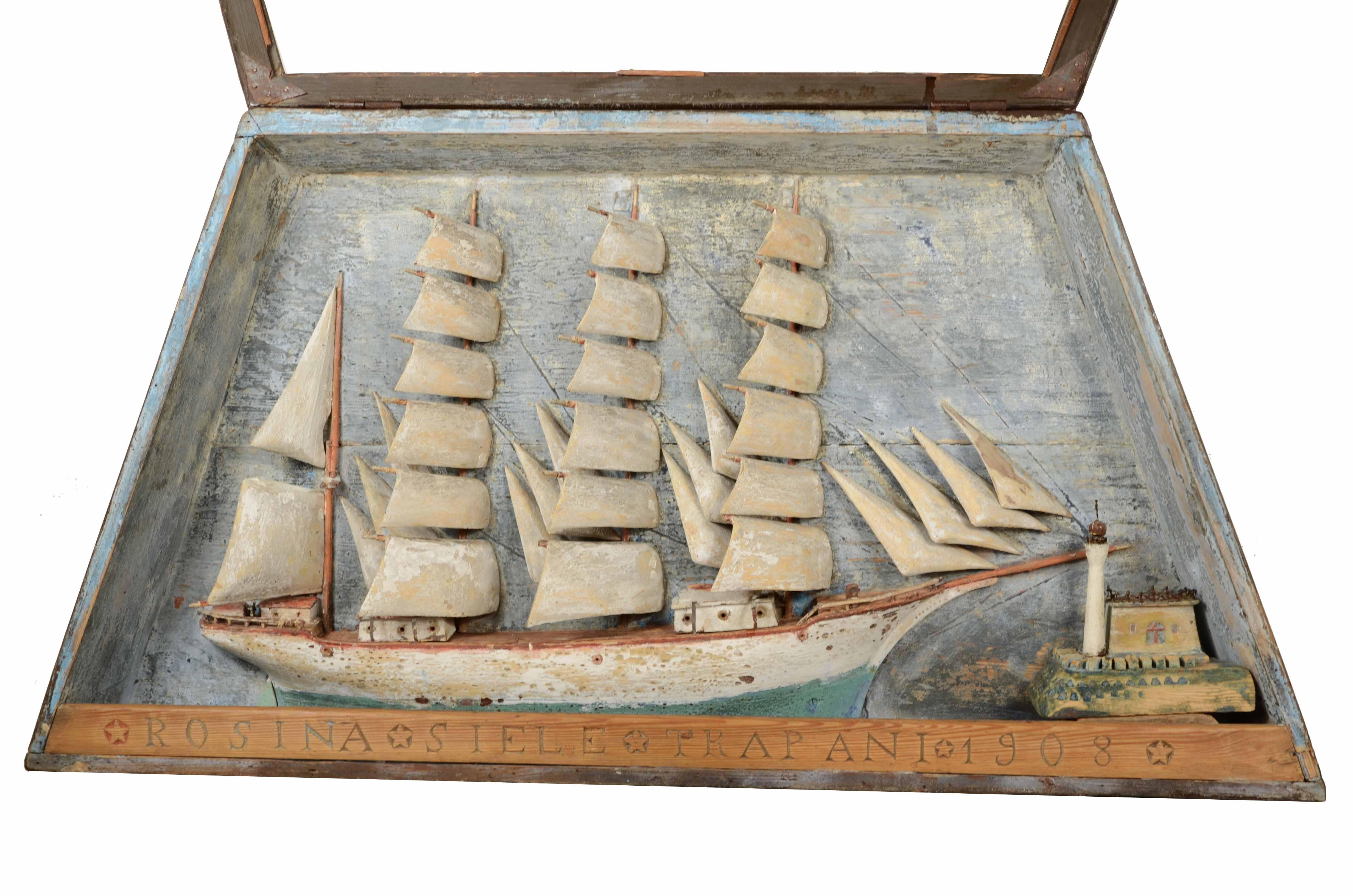 Diorama nautico raffigurante il mezzo scafo in navigazione a vele spiegate del  veliero trapanese Rosina Siele  variiert 1908 und  alloggiato nella sua originale  teca in legno e vetro dalla forma trapezoidale con sportello apribile.  Buono stato,