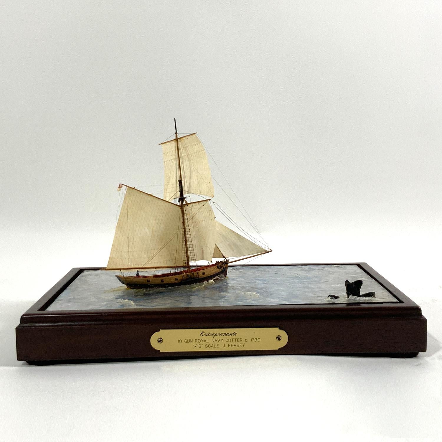 Clear water diorama showing the Ten Gun Royal Navy Cutter, Entreprenante Circa 1790. The model is built to a scale of one sixteenth inch equals one foot. The vessel appears to be sailing through deep clear water. An exceptional technique where