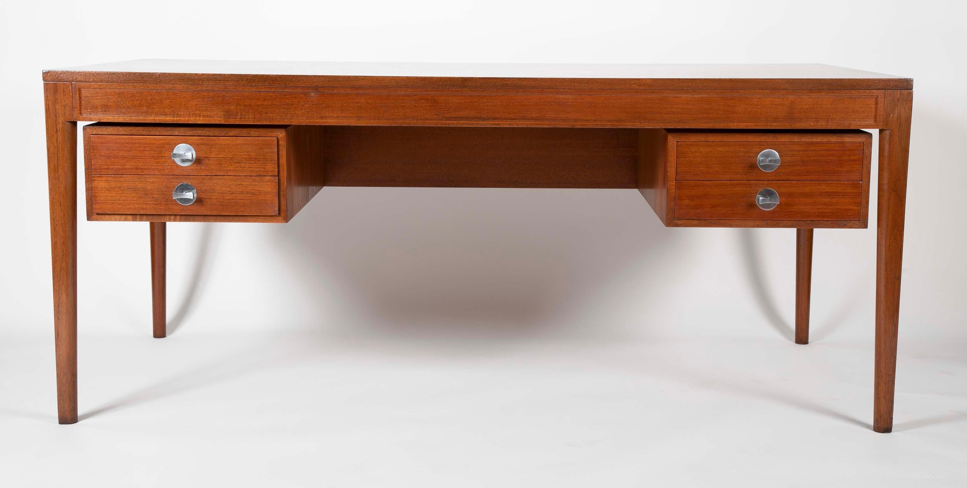 A distinctive looking teak desk with brushed aluminum hardware; the Diplomat desk designed by Finn Juhl in 1958 is anything but Bureaucratic. The quality standards of this desk are of the highest degree in keeping with Finn Juhls enduring reputation