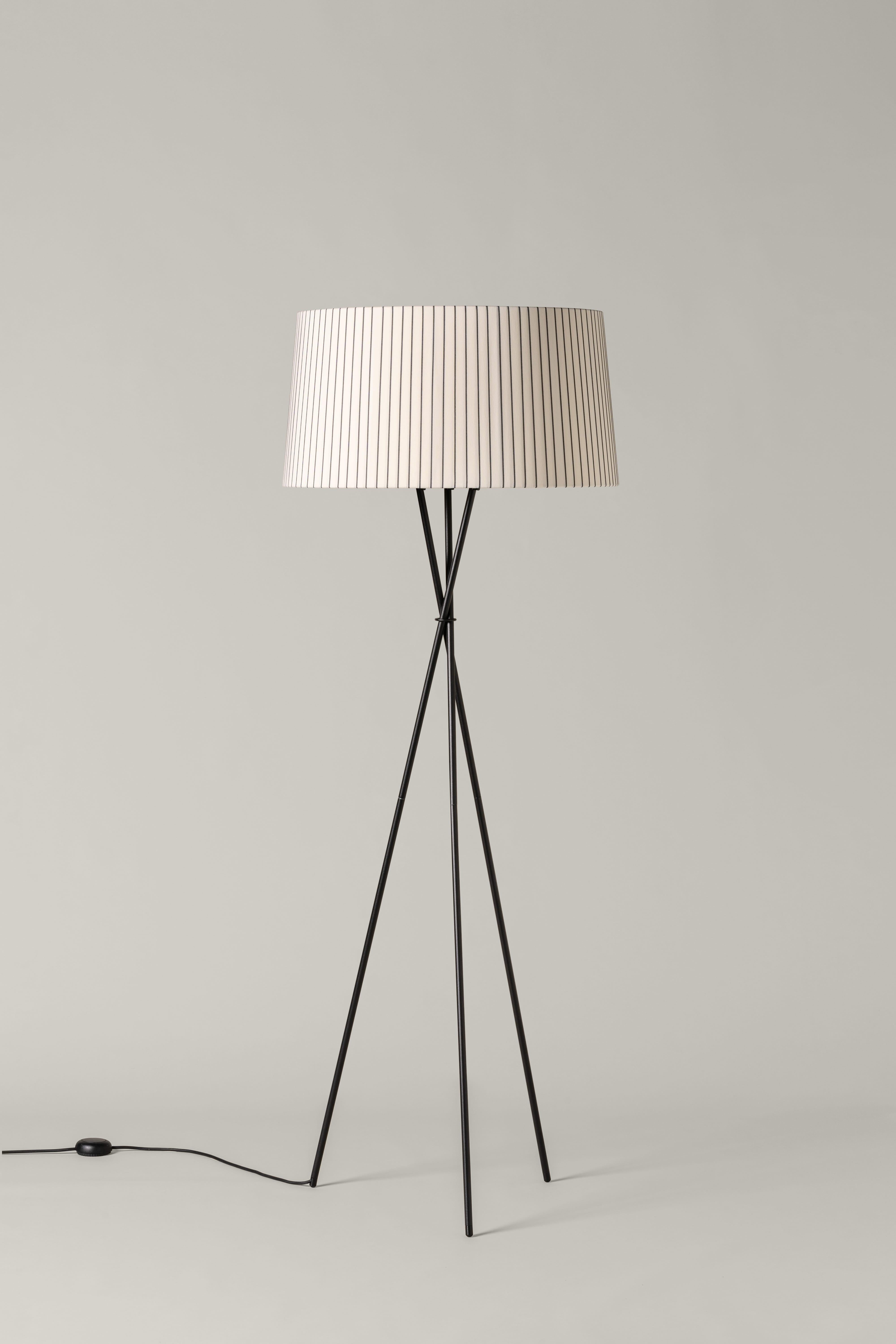 Diplomática Trípode G5 floor lamp by Santa & Cole.
Dimensions: D 62 x H 168 cm.
Materials: Metal, diplomática stripe ribbon lampshade.
Available in other colors.

Trípode humanises neutral spaces with its colourful and functional sobriety. The