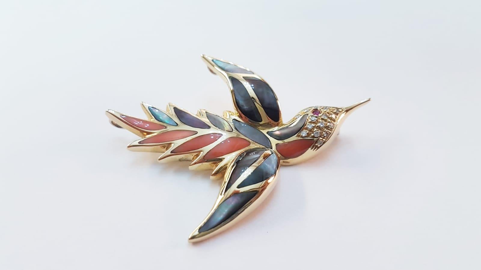 1980s delightful bird brooch by Dirce Repossi, crafted in 18K Yellow Gold, featuring 0,16 carats of brilliant cut diamonds, accented by  0,02 carats of rubies, pink coral and mother-of-pearl. This vibrant and colorful brooch is a must have for all