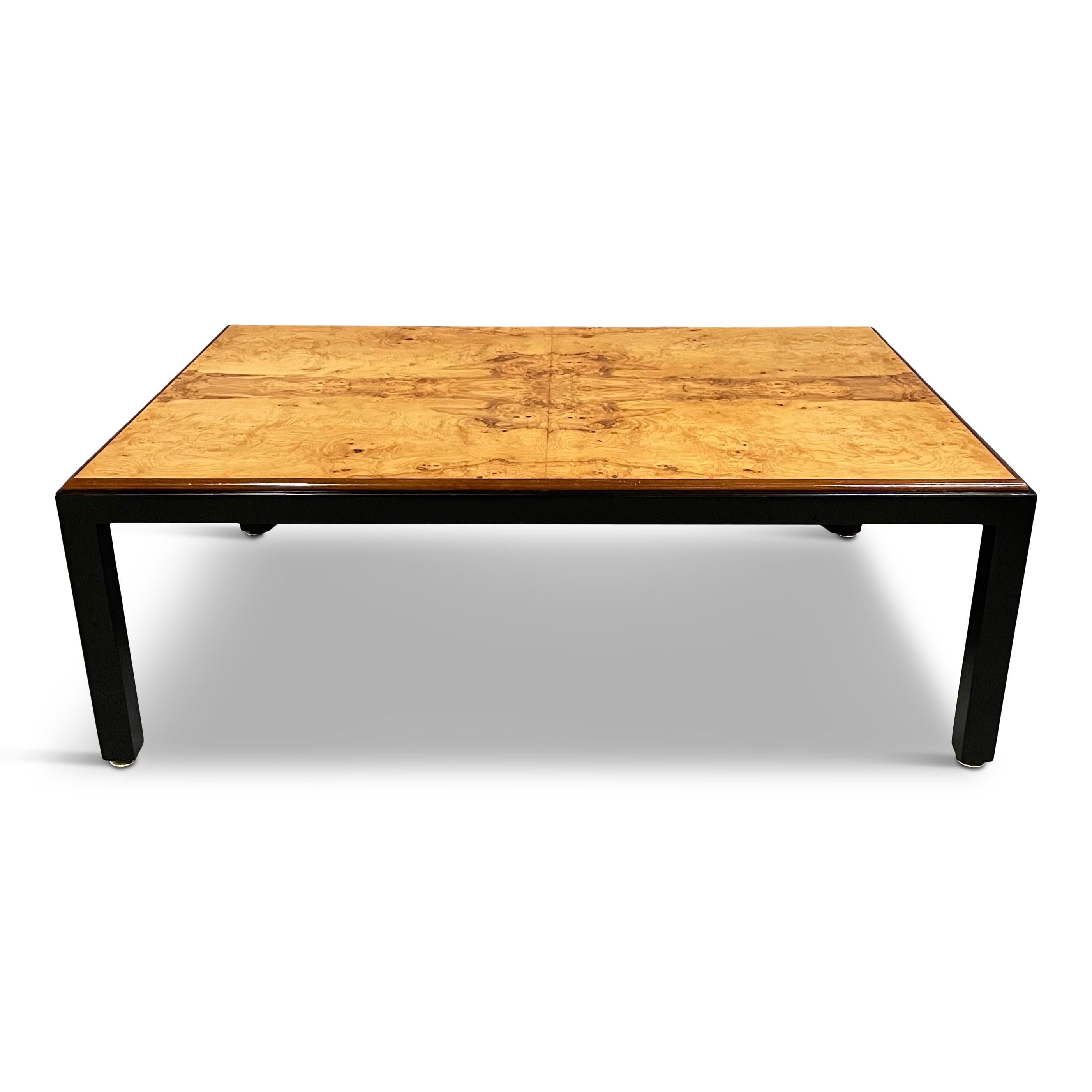 This dynamic, impressively sized coffee table has a beautiful burl top and ebonite frame with brass levelers.
