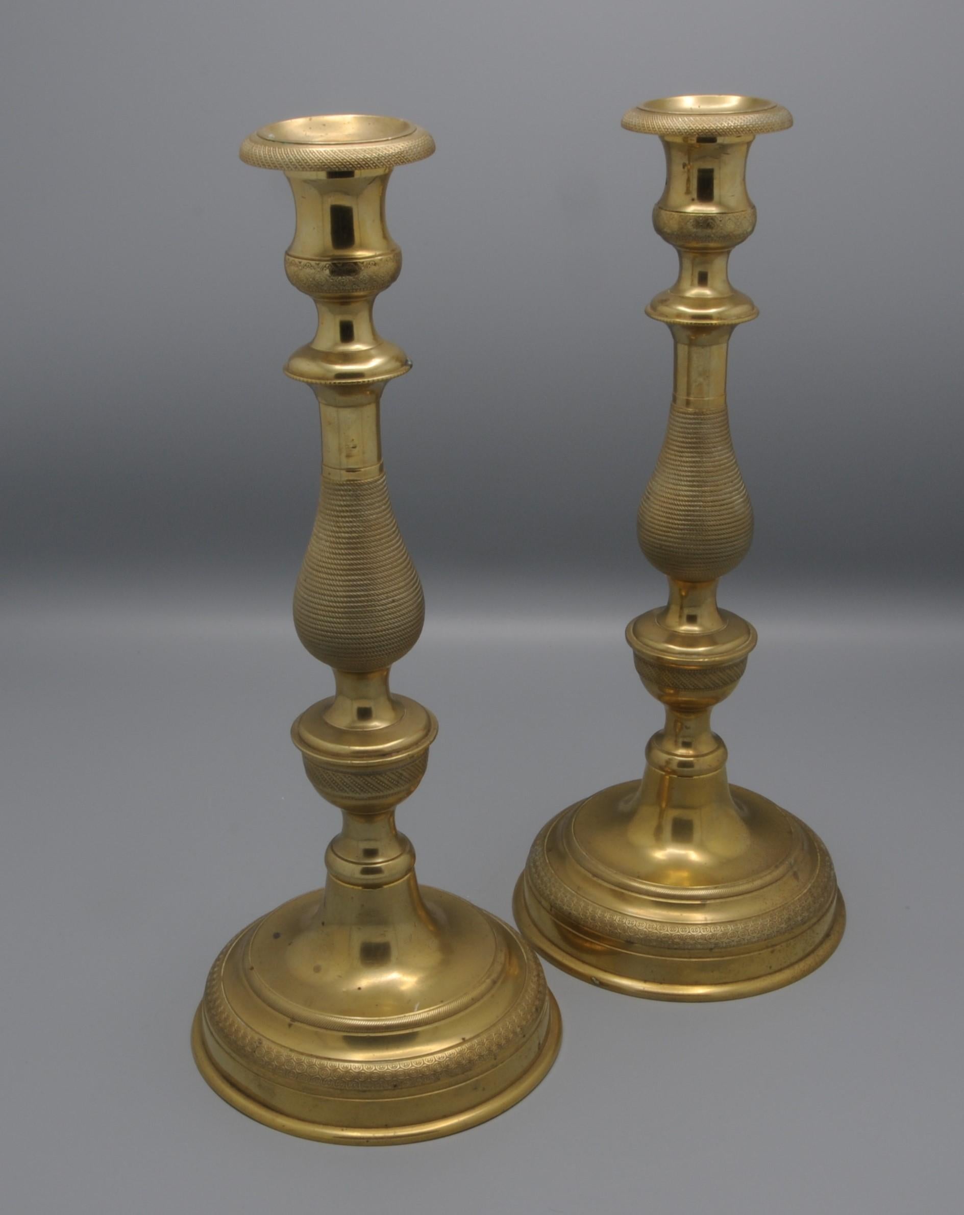 French Directoire Period brass Candlesticks. 
The detachable socles set within urn shaped holders, baluster-shaped stems, terminating on circular bases.
Some rubbing and wear.