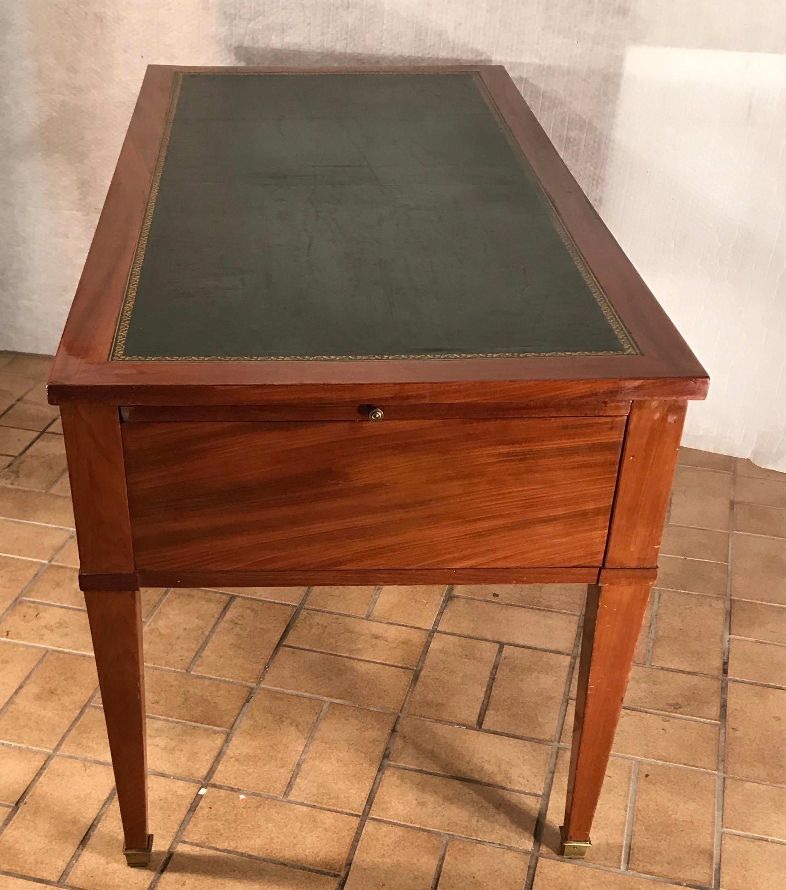 Directoire Bureau Plat, France, circa 1800.
Spacious and chic Directoire desk and the perfect piece of furniture for any home office. 
The bureau plat has an elegant mahogany veneer and a leather covering (later) on the top. Three drawers offer a