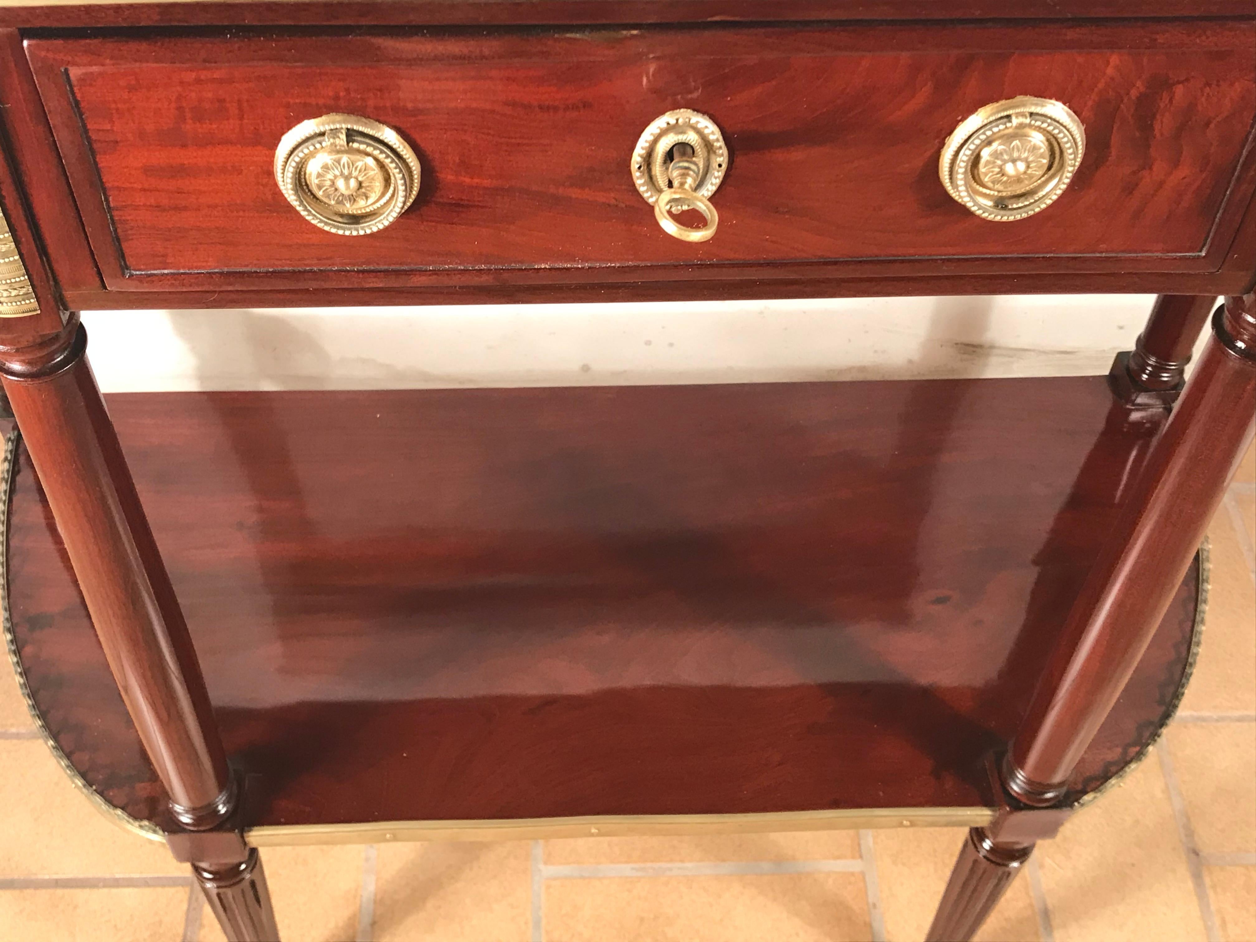 Directoire console table, France, circa 1800.
This Classic Directoire French console table has a beautiful mahogany veneer. The brass fittings are original. The marble top is framed by a pierced brass railing. The console table has one central