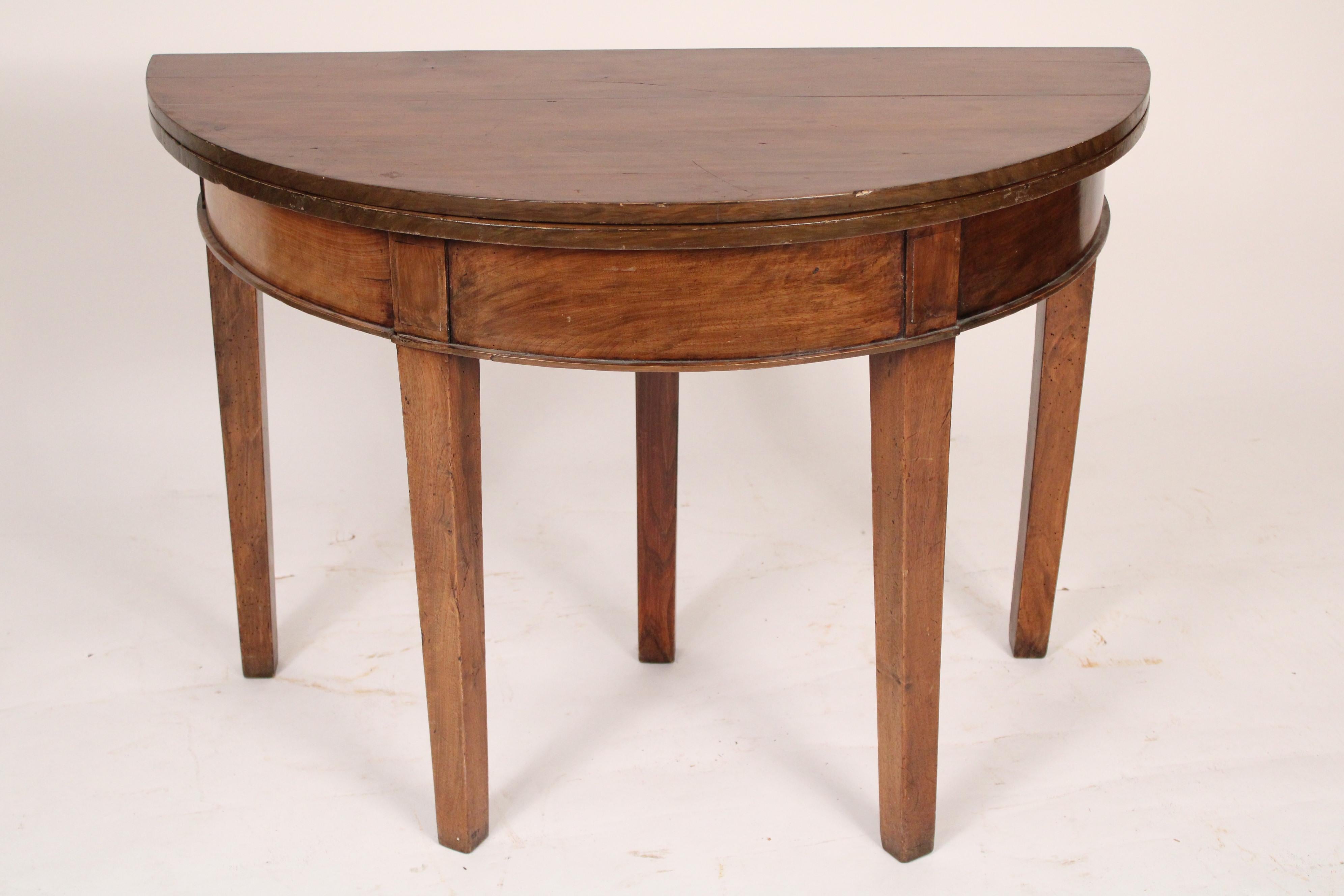 Directoire mixed wood, walnut and fruit wood, demi lune games table, circa 1820. With a demi lune top, 3 frieze panels, resting on 5 square tapered legs. When opened the back leg pulls straight out to support the top. Dimensions of top when opened