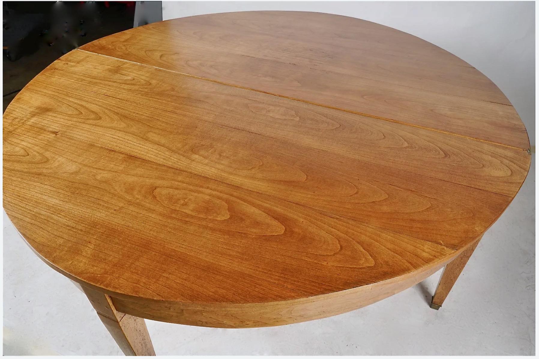 This is a great uncommonly large folder-over demilune dining table. The table is crafted of solid beautifully grained pearwood. The shaped legs terminate in their original brass caps; all five of the legs are in good condition with indications of