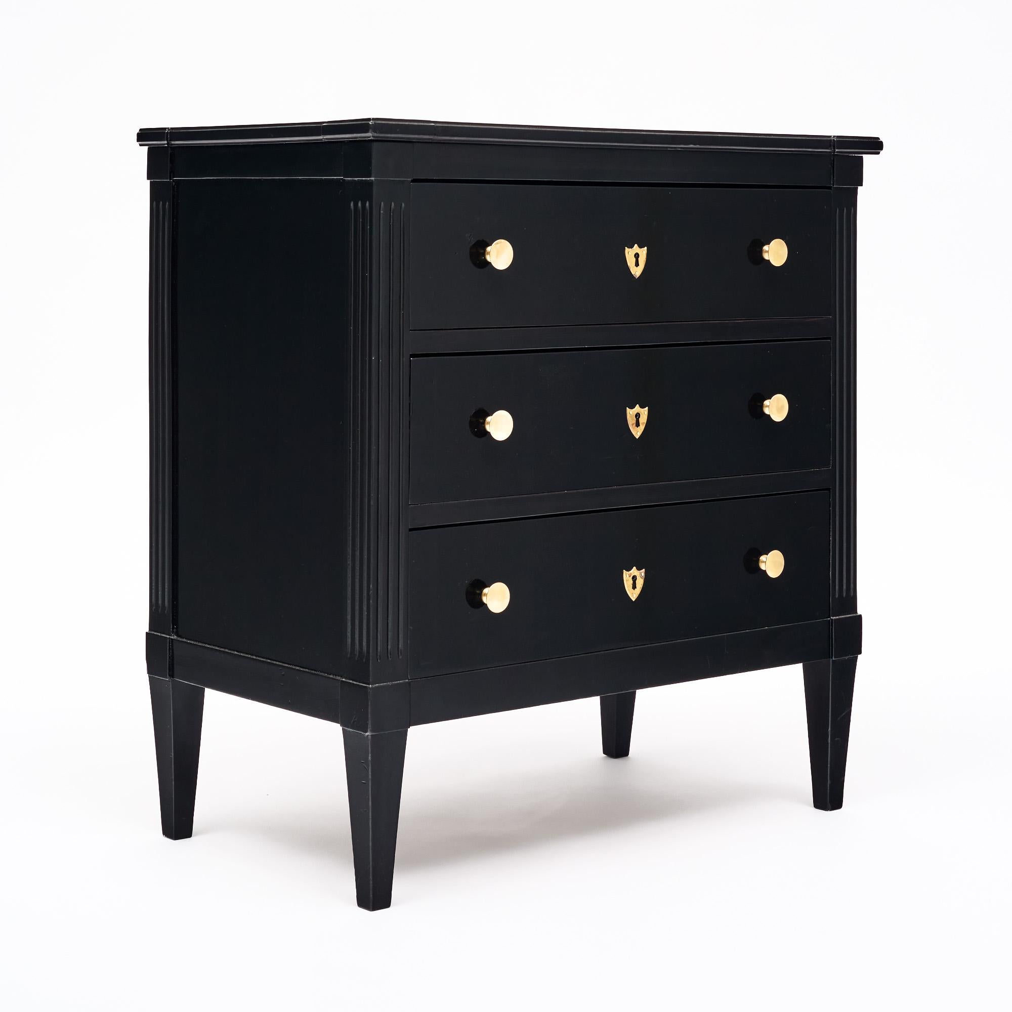 Chest of drawers from France in the Directoire style. This petite chest of drawers is made of mahogany that has been ebonized and finished with a lustrous French polish of museum quality. This piece has three dovetailed drawers, and gilt brass pulls