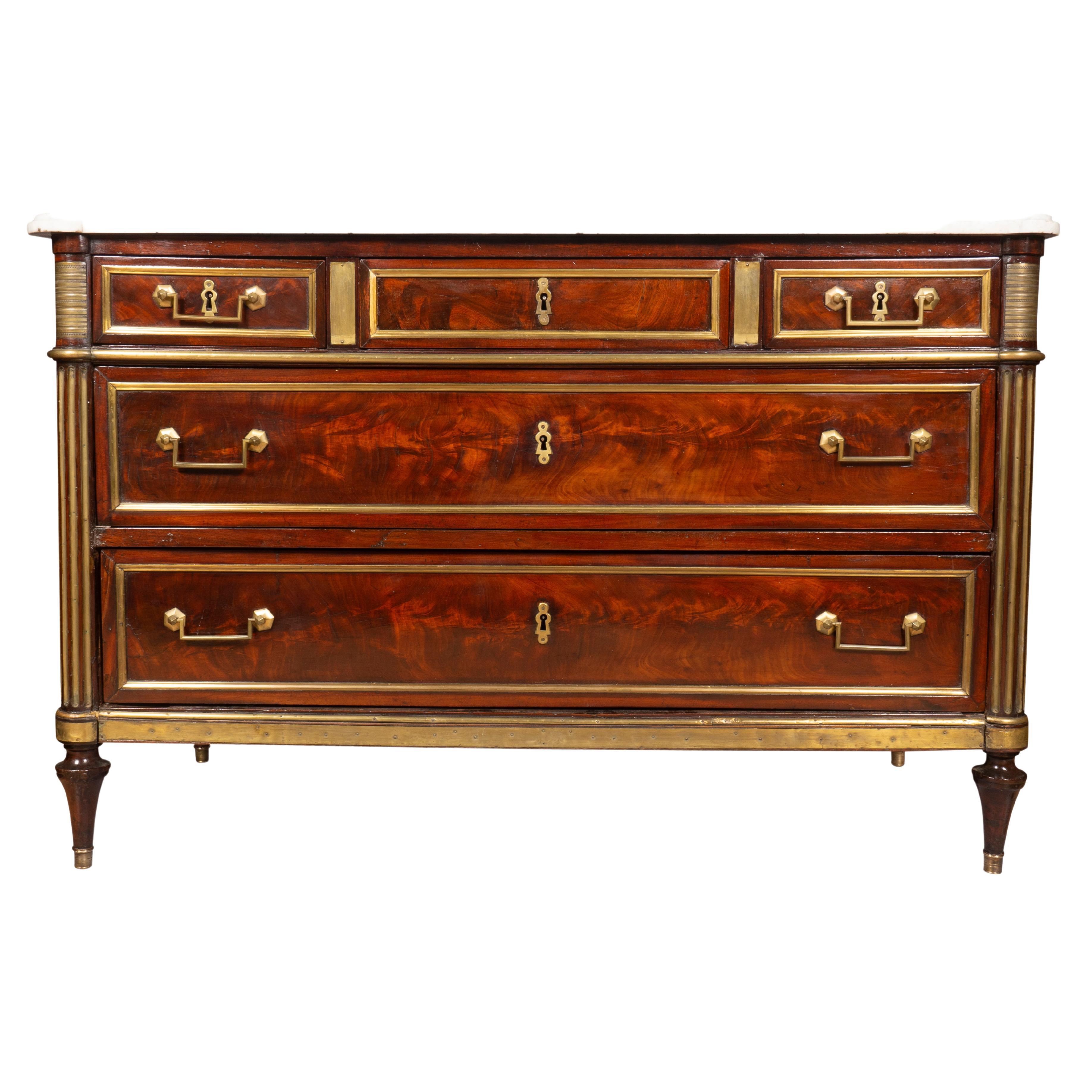 With a rectangular white marble top with rounded corners over a conforming case with three smaller top drawers over two long drawers each with brass moldings and square bail handles all flanked by inset brass fluted columns ,the sides of case with