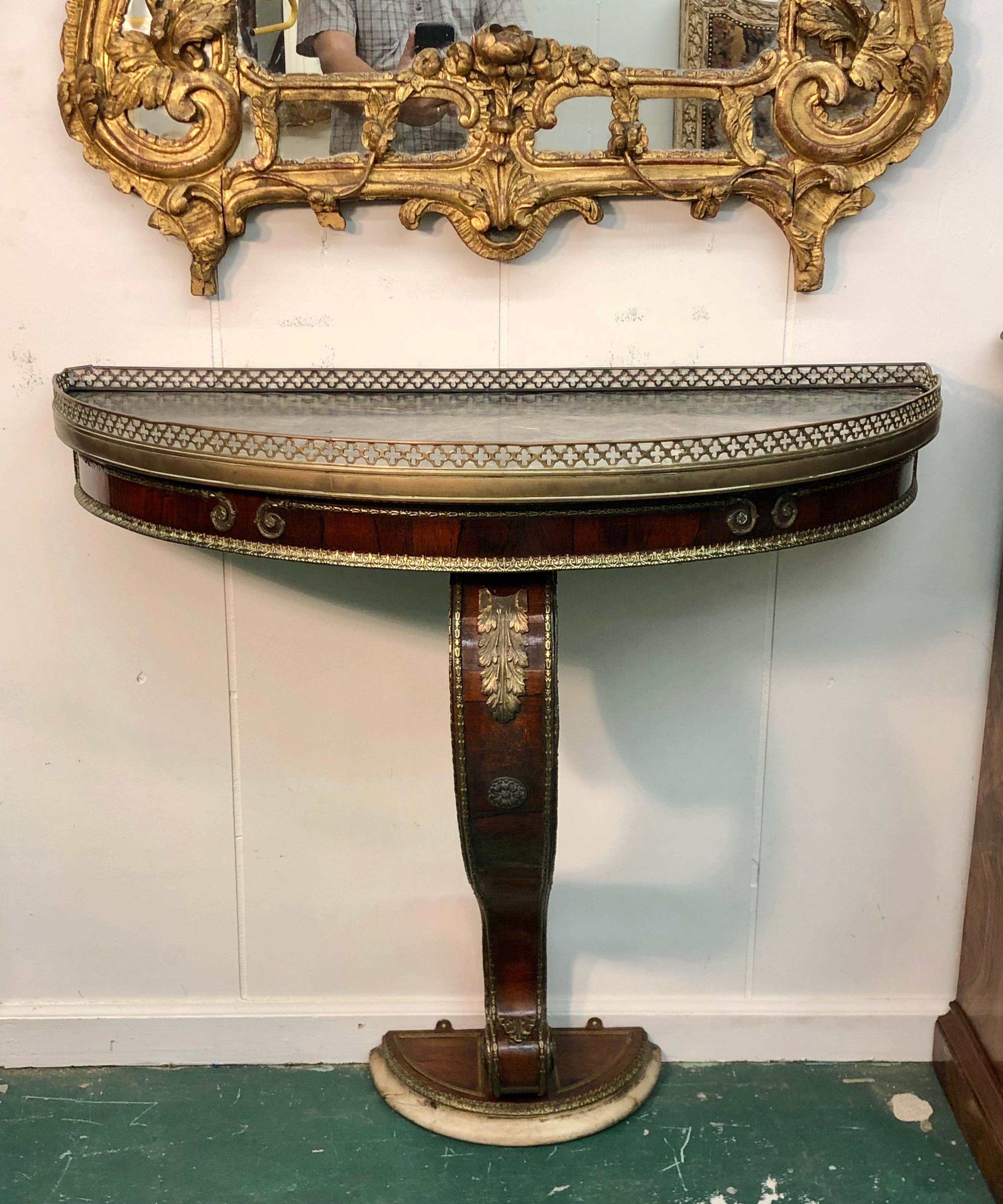 Directoire Period Marble Top Rosewood French Console with bronze mounts from the Late 18th Century. The Directoire Console has a hand chiseled marble top mounted with a bronze gallery. The Rosewood console has exceptional chiseled bronze mounts.